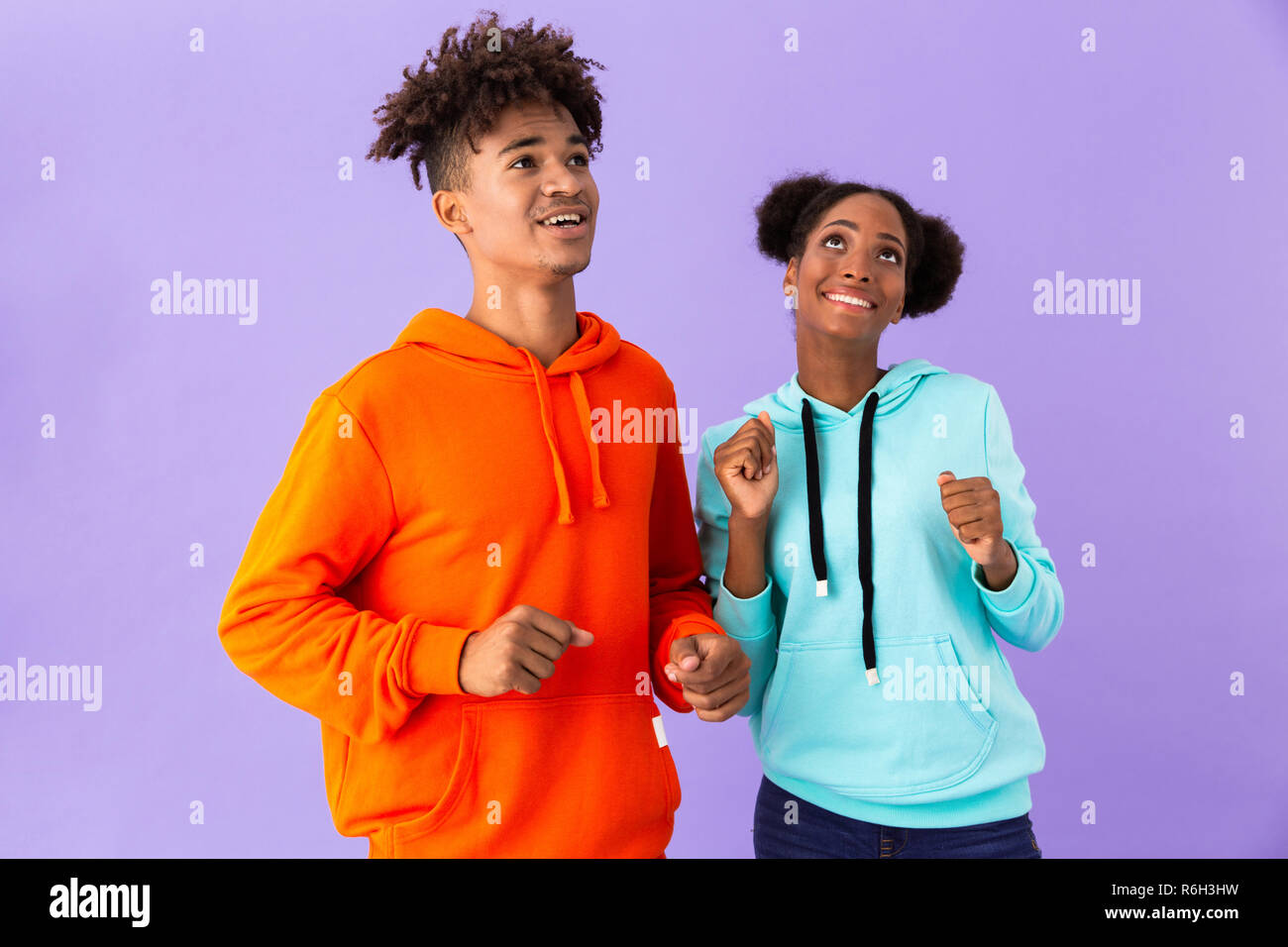 Photo of joyful african american brother and sister dancing and singing