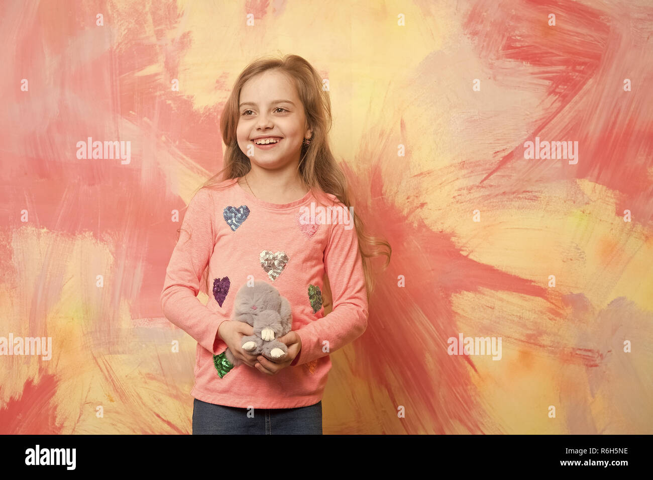 girl, happy small child with curly hair, rabbit or hare toy on colorful  background Stock Photo - Alamy