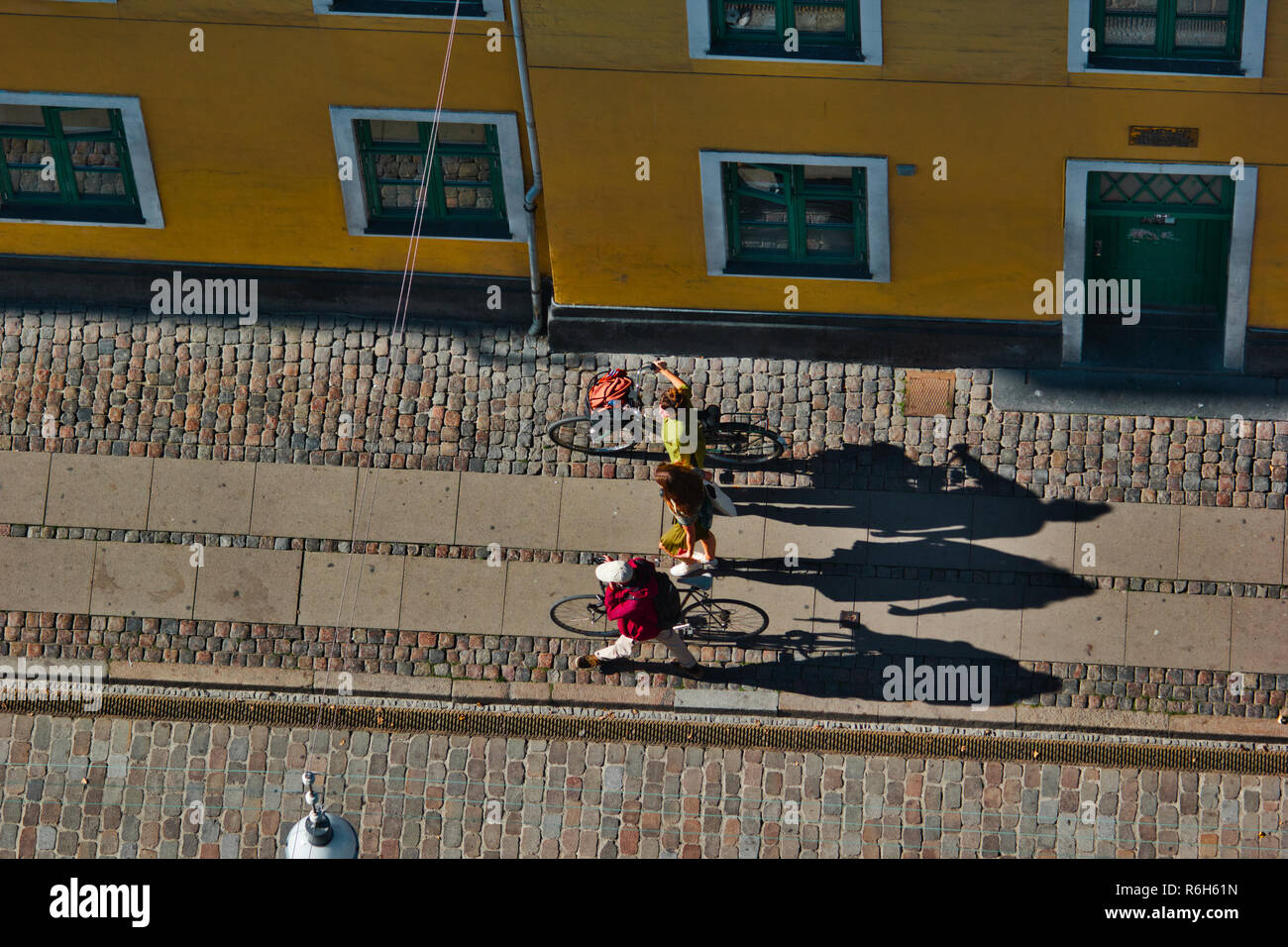 Two cyclists walking pushing bikes, Christianshavn, Copenhagen, Denmark, Scandinavia Stock Photo