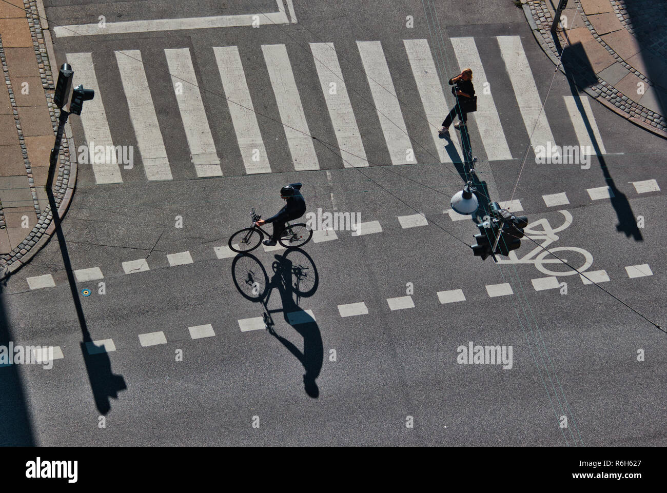 High angle shot of cyclist and pedestrian in bright sunlight, Christianshavn, Copenhagen, Denmark, Scandinavia Stock Photo