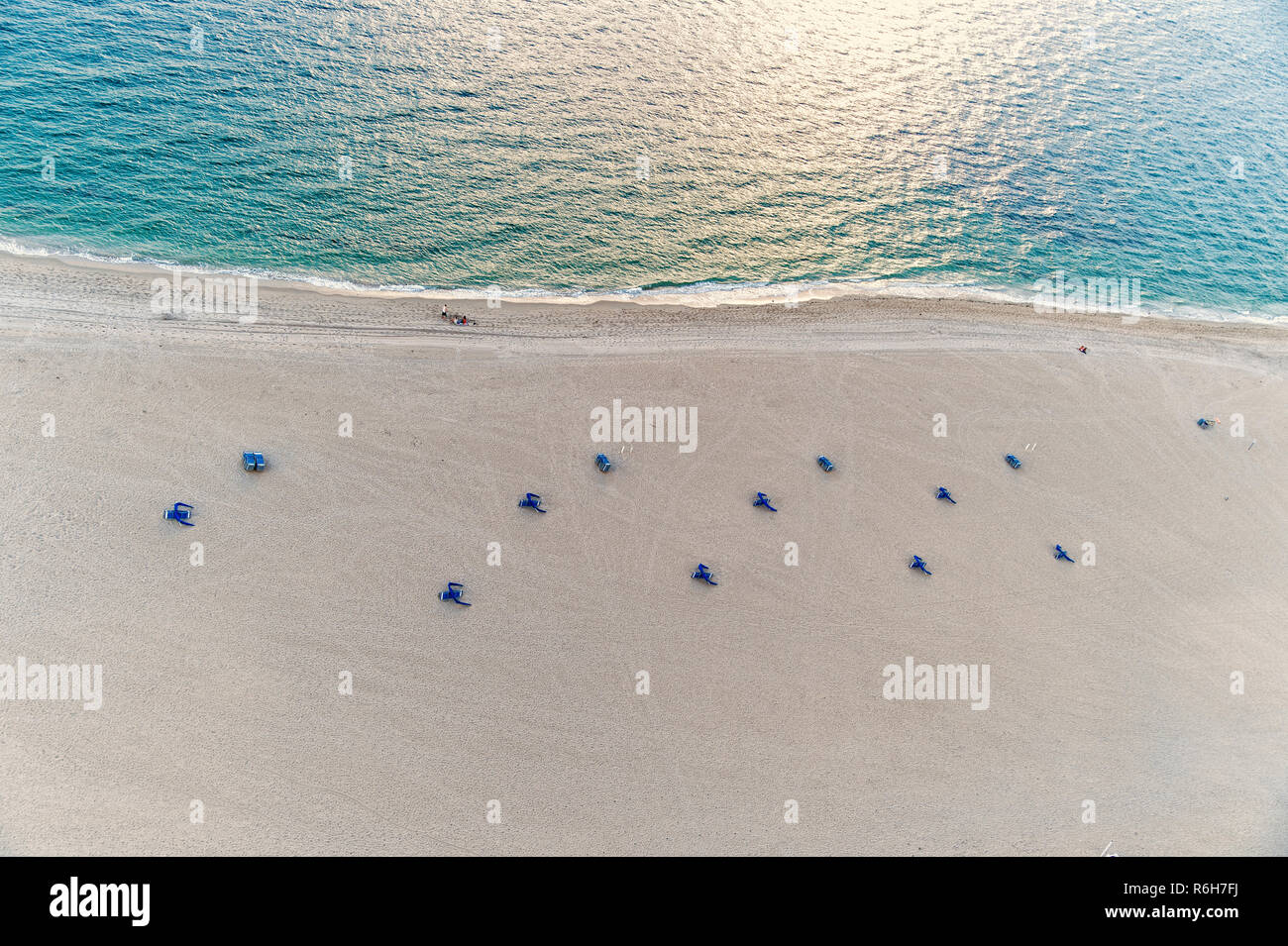 Aerial View On Beach With Blue Chair Umbrellas On Sand Near