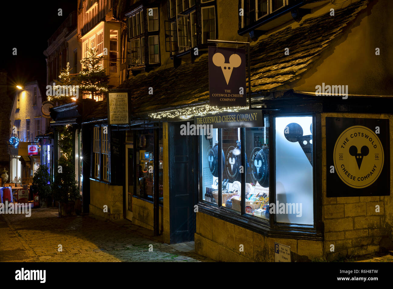 The Cotswold cheese company shop window at night in December. Burford