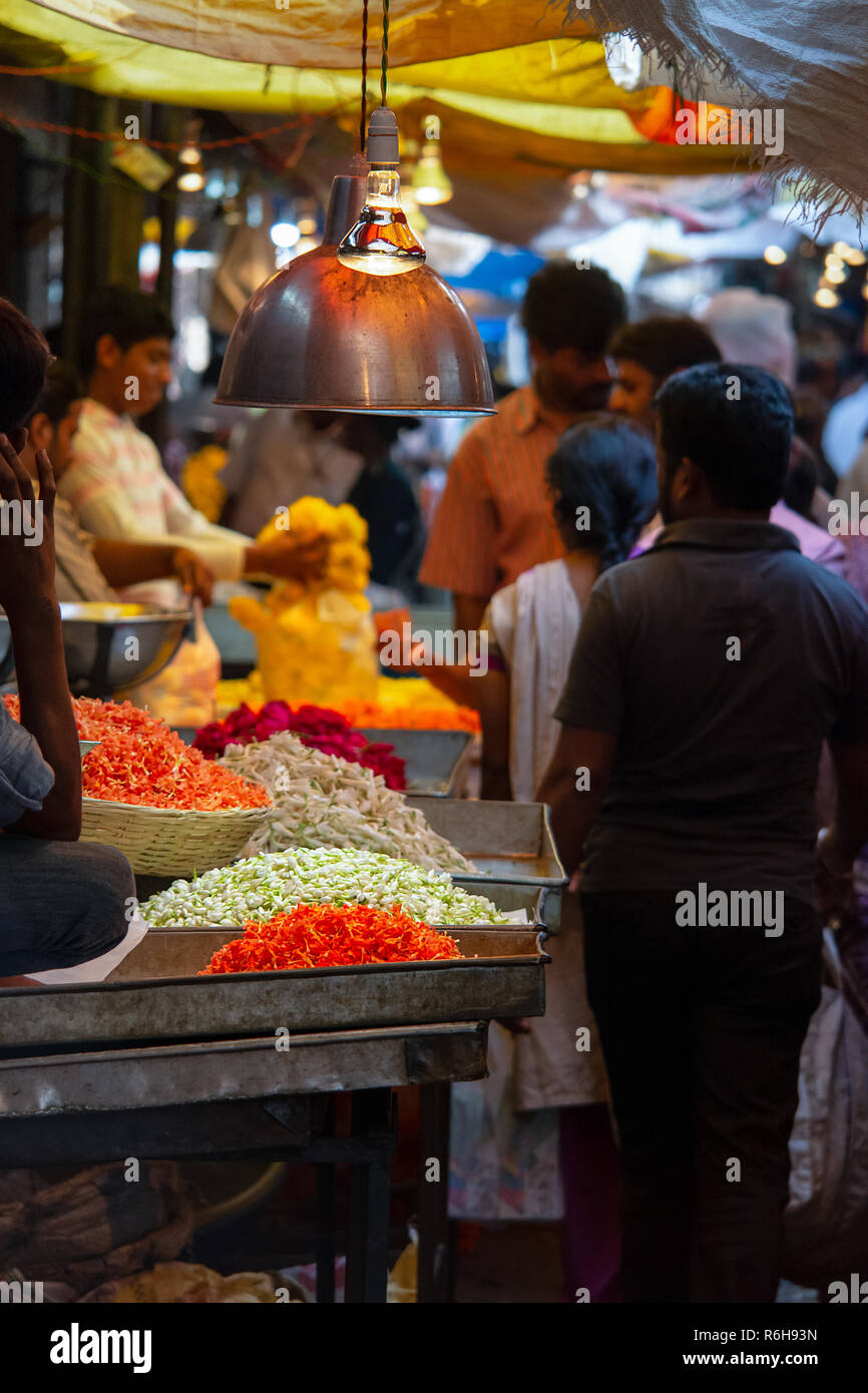 A busy isle of an Indian wholesale flower market. Colourful flowers and