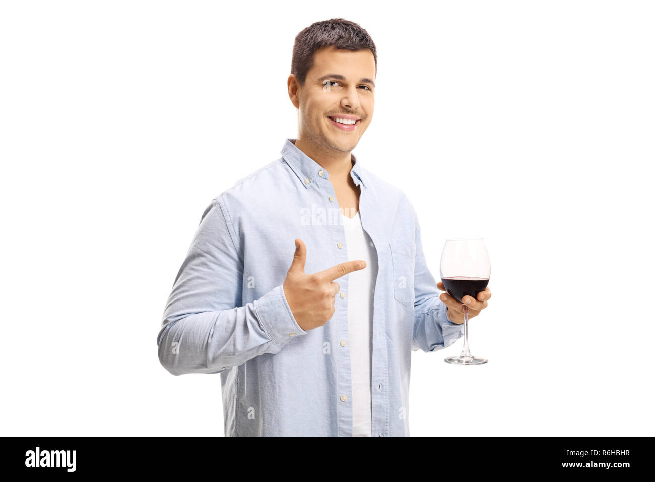 Young man holding a glass of red wine and pointing at it isolated on white background Stock Photo