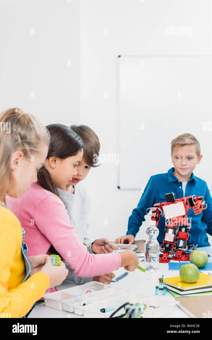 schoolchildren programming robot together during STEM educational class ...
