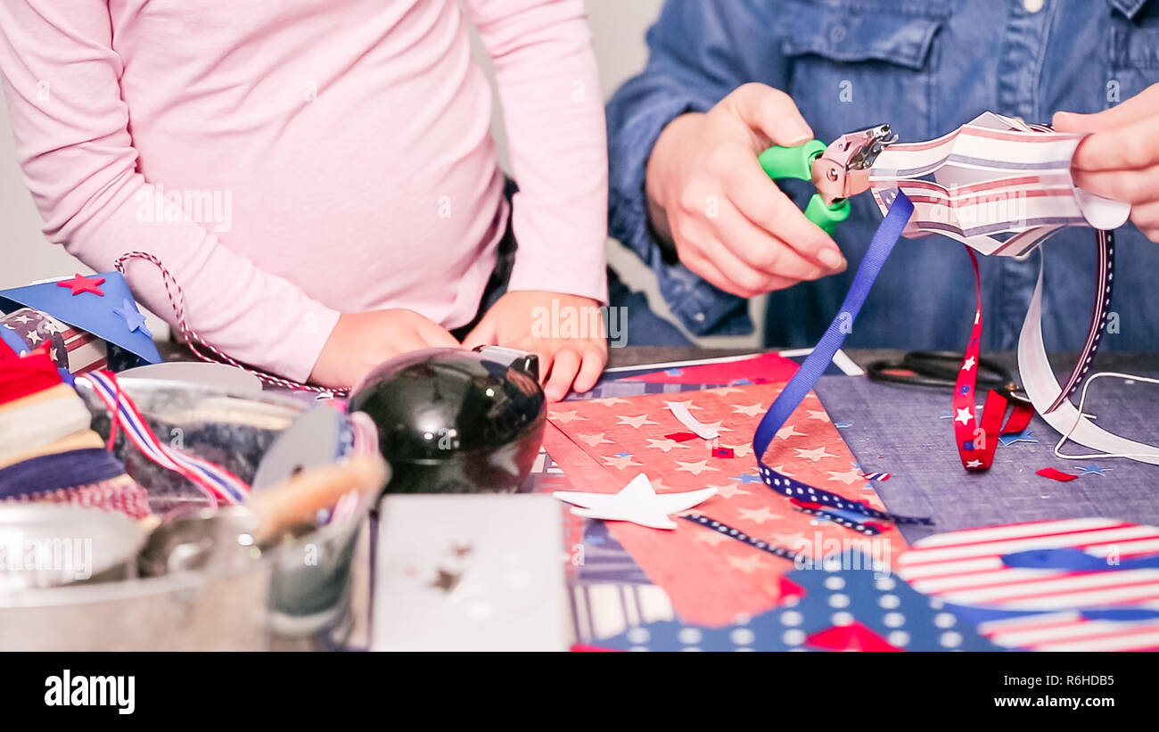 Step by step. Mother and daughter making paper firecrackers for July ...