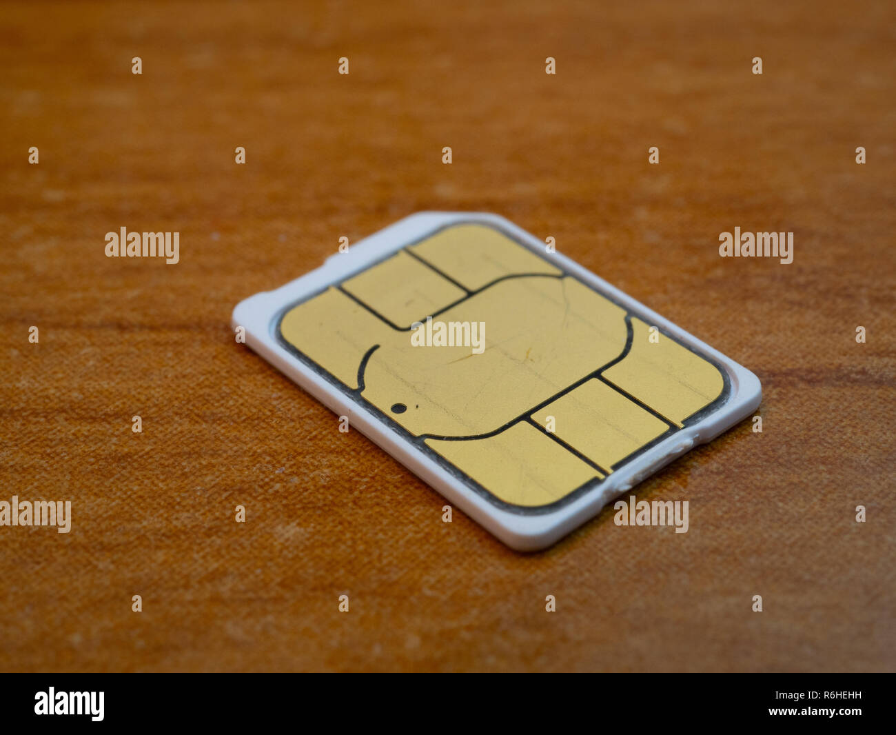 macro close-up shot of nano sim card 5g ready on wooden background. low angle shot Stock Photo