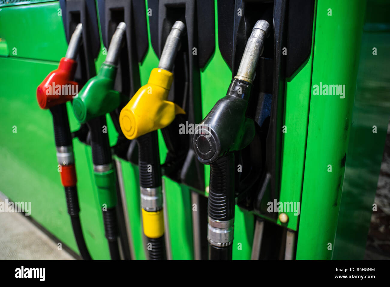 Fueling nozzles in different colors on green bright station Stock Photo