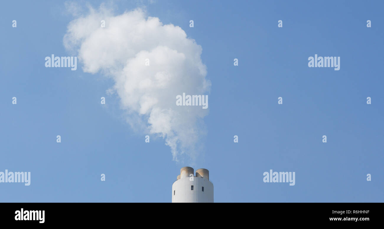 Chimney emit smoke over blue sky Stock Photo - Alamy