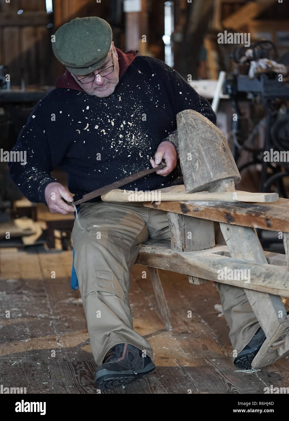 mature adult man works on clapboard an ax-handle Stock Photo