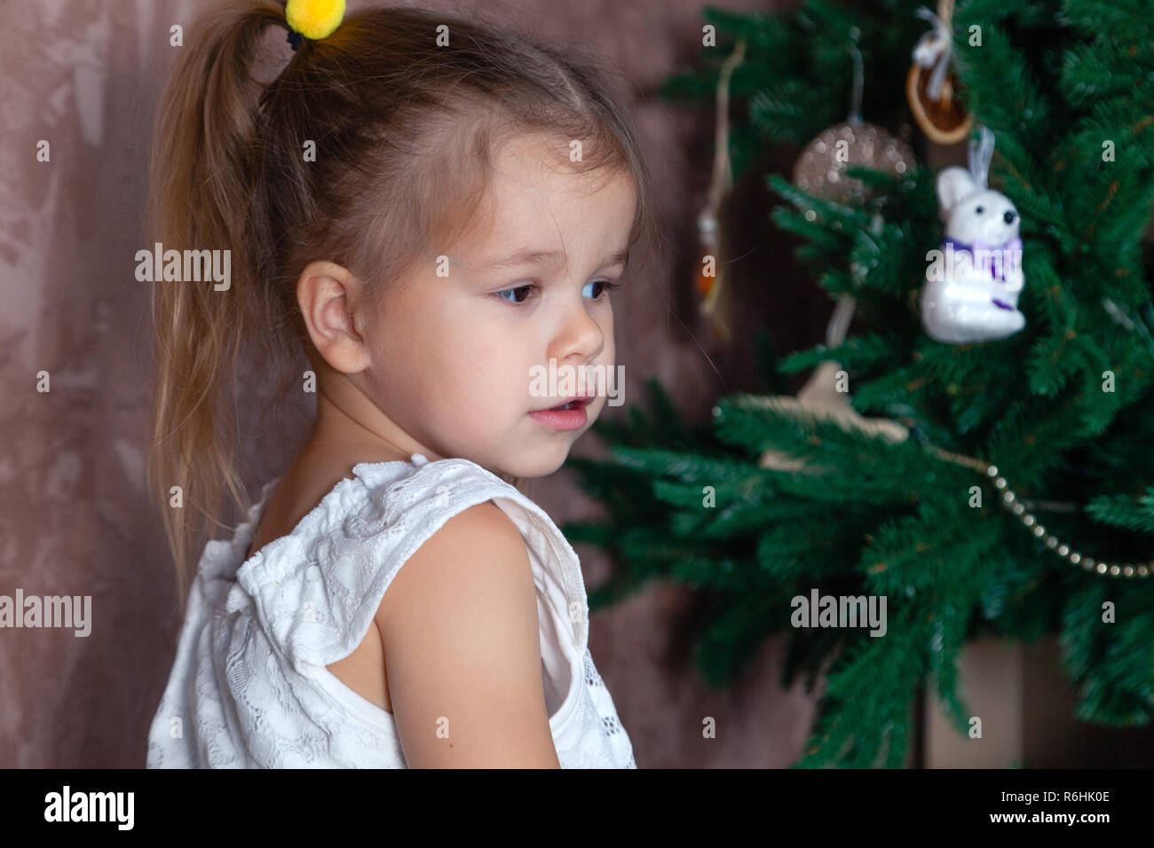 Little Cute Caucasian Baby Girl With Ponytails Helped To Decorate