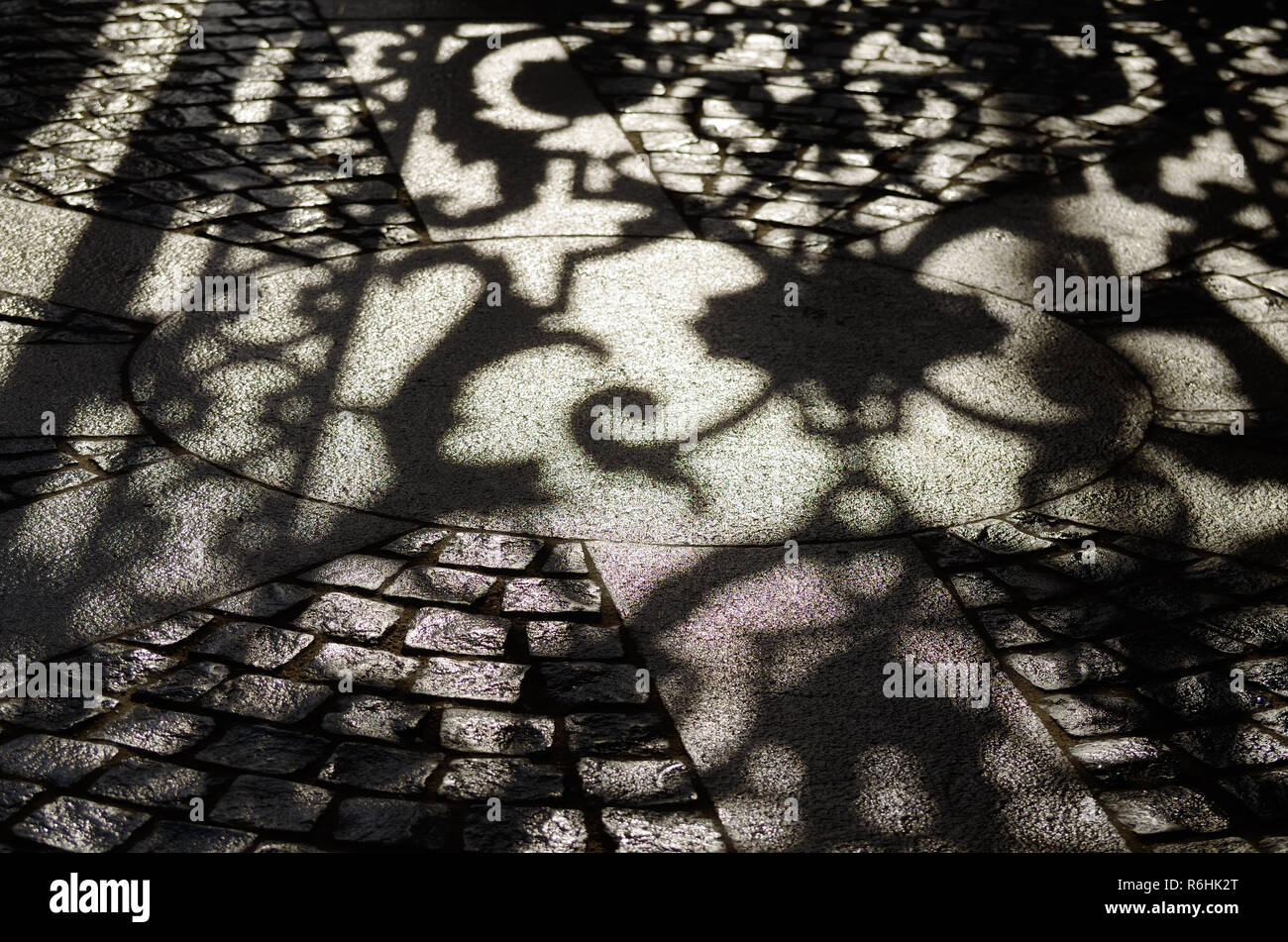 bright sunny day.The contrasting shadow on the pavement from the wrought-iron gate. Stock Photo