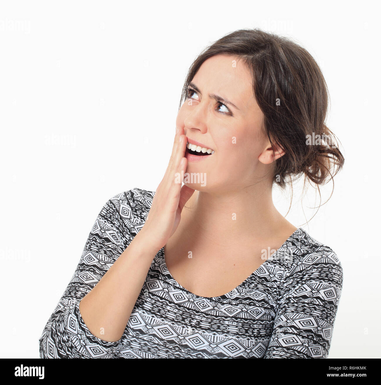 Excited young woman keeping her arm to mouth Stock Photo