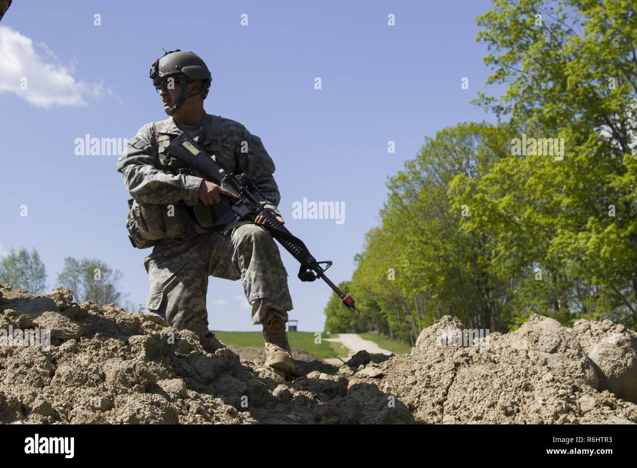 A U.S. Army officer candidate observes soldiers clearing a make-shift bunker during a bunker clearing lane at New Hampshire National Guard Training Site in Center Strafford, Nh., May 19, 2017. Soldiers from Connecticut, Maine, Massachusetts, New Hampshire, New Jersey, New York, Rhode Island, and Vermont participated in the Officer Candidate School Field Leadership Exercise in preparation for graduation and commission. Stock Photo