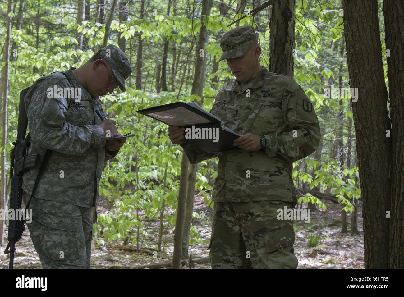 A U.S. Army officer candidate, acting as squad leader, receives operations order for a reconnaissance operations lane at New Hampshire National Guard Training Site in Center Strafford, Nh., May 19, 2017. Soldiers from Connecticut, Maine, Massachusetts, New Hampshire, New Jersey, New York, Rhode Island, and Vermont participated in the Officer Candidate School Field Leadership Exercise in preparation for graduation and commission. Stock Photo