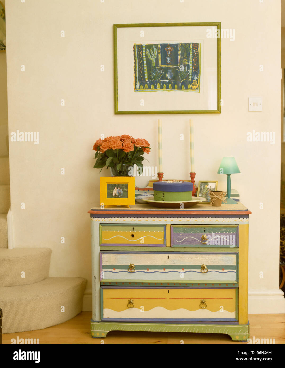 Colourfully painted chest of drawers in small hall Stock Photo