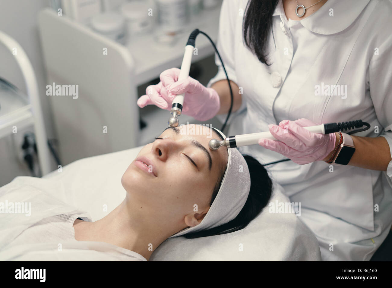 Model with closed eyes and hand's of doctor. Rejuvenating facial