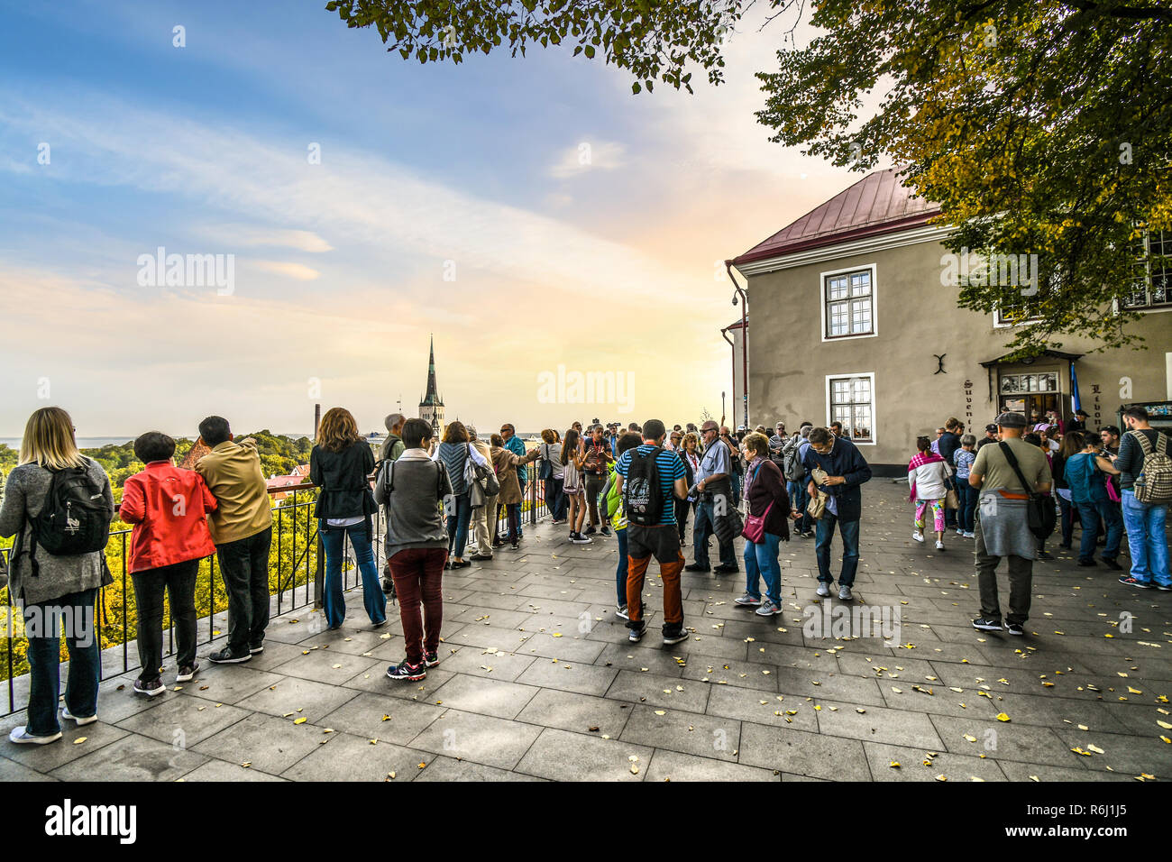 A crowd of tourists visit Toompea Hill Patkuli Overlook to enjoy a view of the Town Hall tower and ancient walled medieval city of Tallinn, Estonia Stock Photo