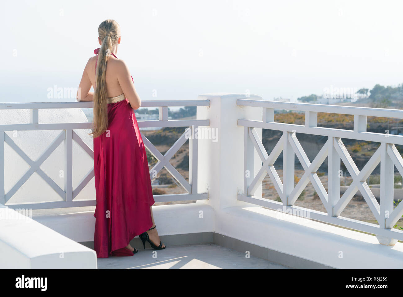 attractive girl in red dress posing near the pool Stock Photo - Alamy