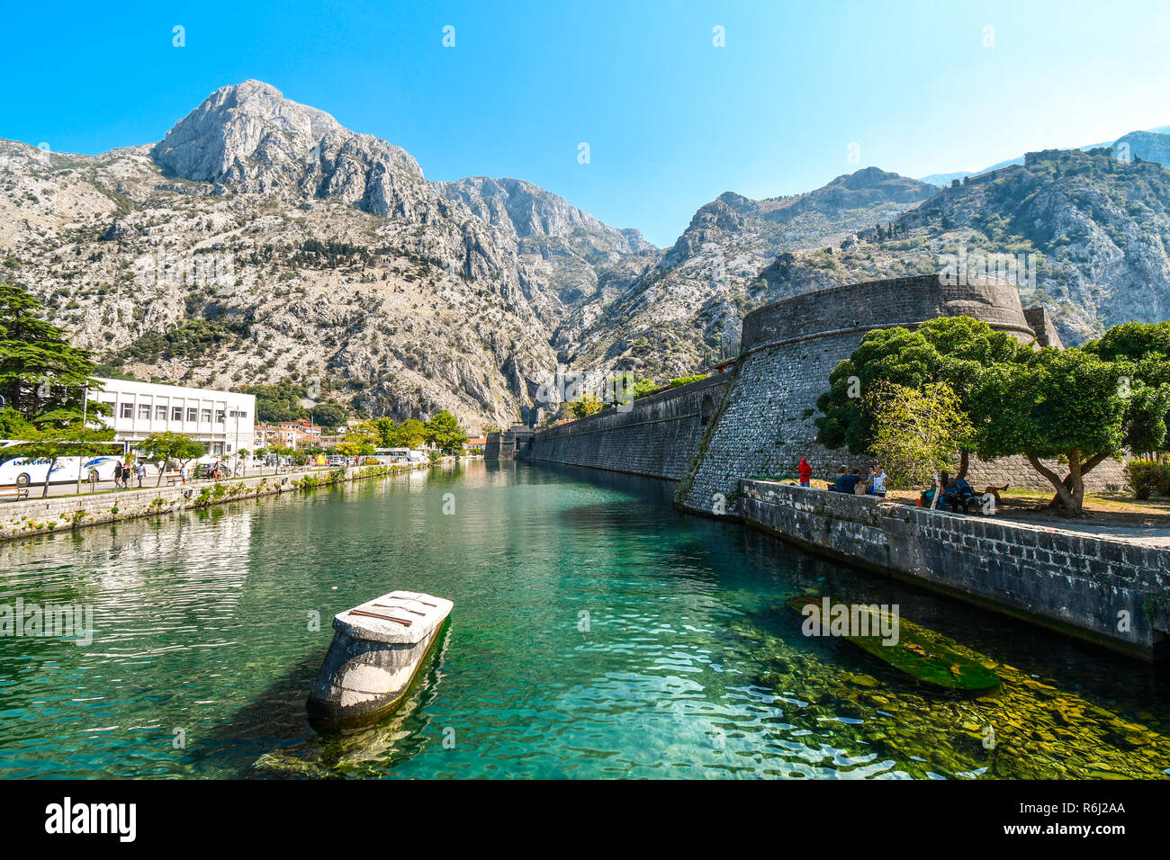 The medieval city walls and moat separating old and new town, with the mountains behind in the Adriatic ancient city of Kotor, Montenegro. Stock Photo