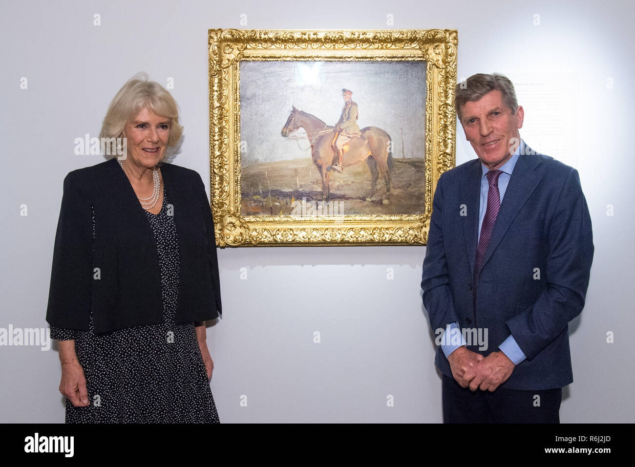 The Duchess of Cornwall views the painting 'Major-General The Right Honourable J.E.B. Seely' alongside Seely's grandson Brough Scott, during a visit to the 'Alfred Munnings: War Artist, 1918' exhibition, at the National Army Museum, in London, which features over forty works of art by the war artist that have been brought together for the first time in a century. Stock Photo