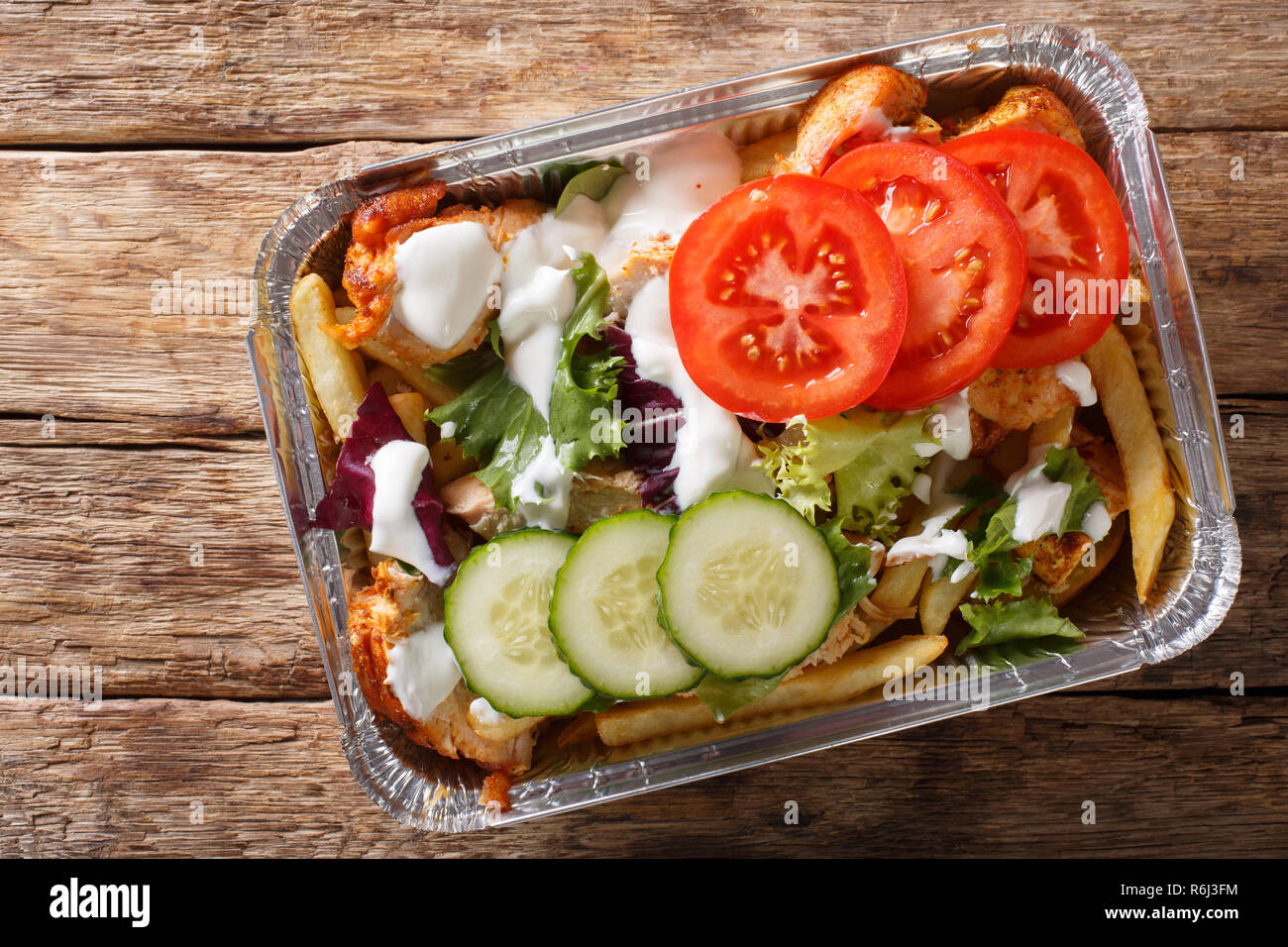 Traditional Dutch fast food kapsalon of french fries, chicken, fresh ...