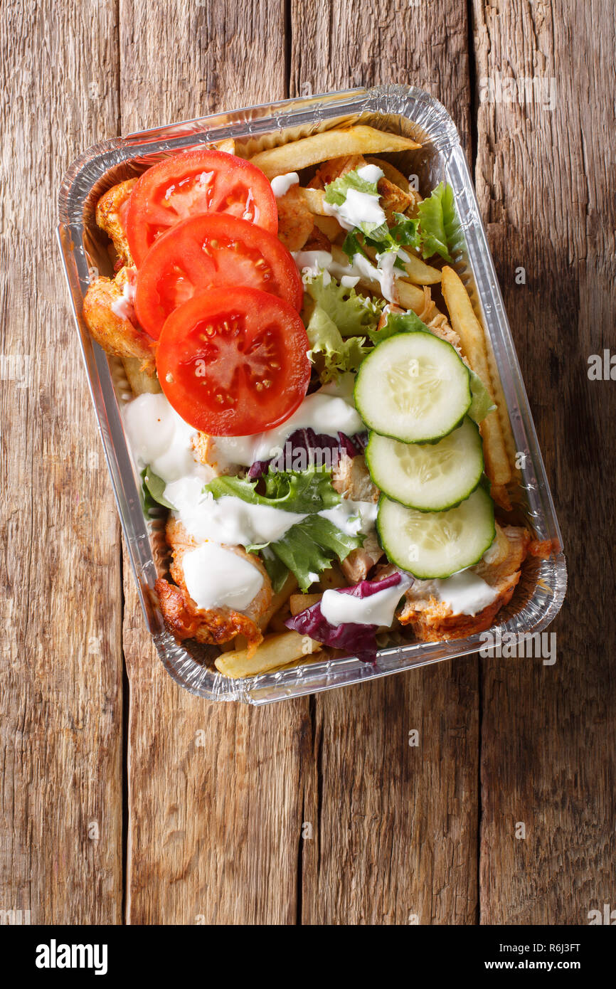 Traditional Dutch fast food kapsalon of french fries, chicken, fresh ...