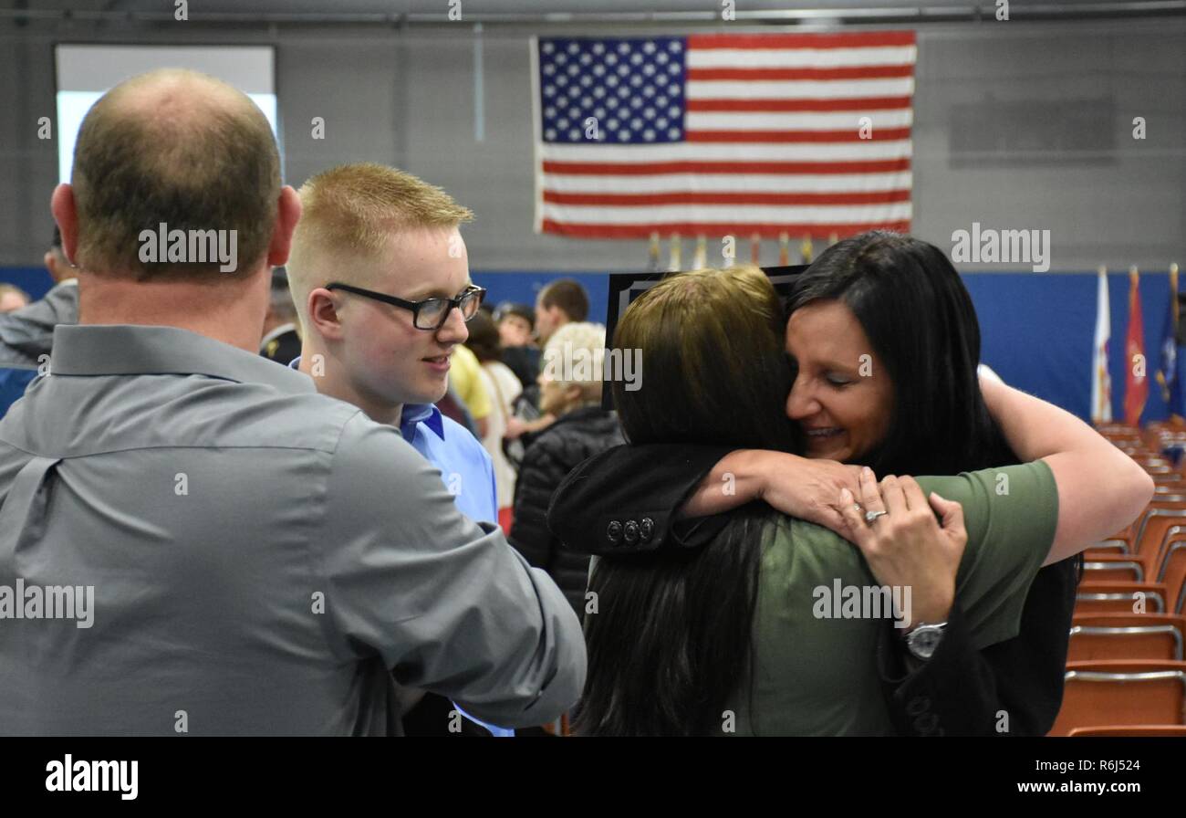 A proud future U.S. Army Reserve mom hugs her daughter, Calista Lage, after she received an "Our Community Salutes" certificate from Medal of Honor recipient Command Sergeant Major (Ret.) Kenneth E. Stumpf and Fort McCoy Senior Commander and 88th Regional Support Command Commanding General, Maj. Gen. Patrick Reinert during an “Our Community Salutes” event at Fort McCoy, Wisconsin on Armed Forces Day, May 20, to recognize and honor graduating high school seniors who have committed to enlist in the Armed Forces following high school graduation. Stock Photo
