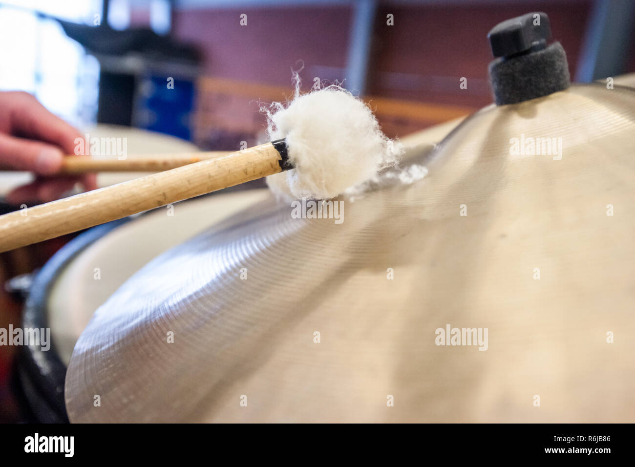 Musician plays the cymbals of a kettledrum with drumstick Stock Photo