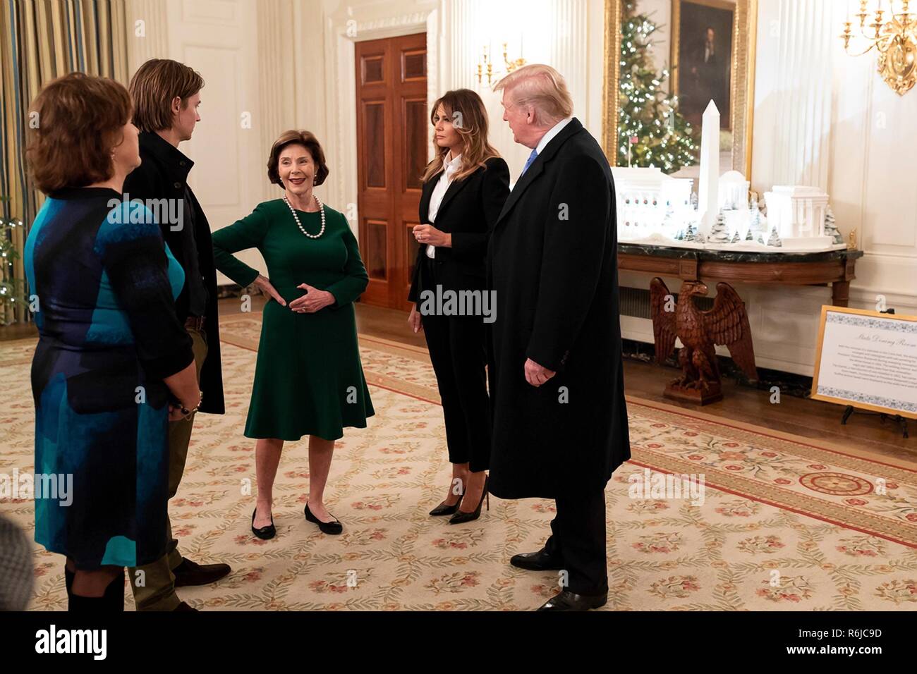 Washington DC, USA. 4th December, 2018. U.S President Donald Trump and First Lady Melania Trump chat with former First Lady Laura Bush, center, and Bush family members in the State Dining Room of the White House December 4, 2018 in Washington, DC. Bush is staying at Blair House to attend the memorial service for his father the late President George H.W. Bush. Credit: Planetpix/Alamy Live News Stock Photo