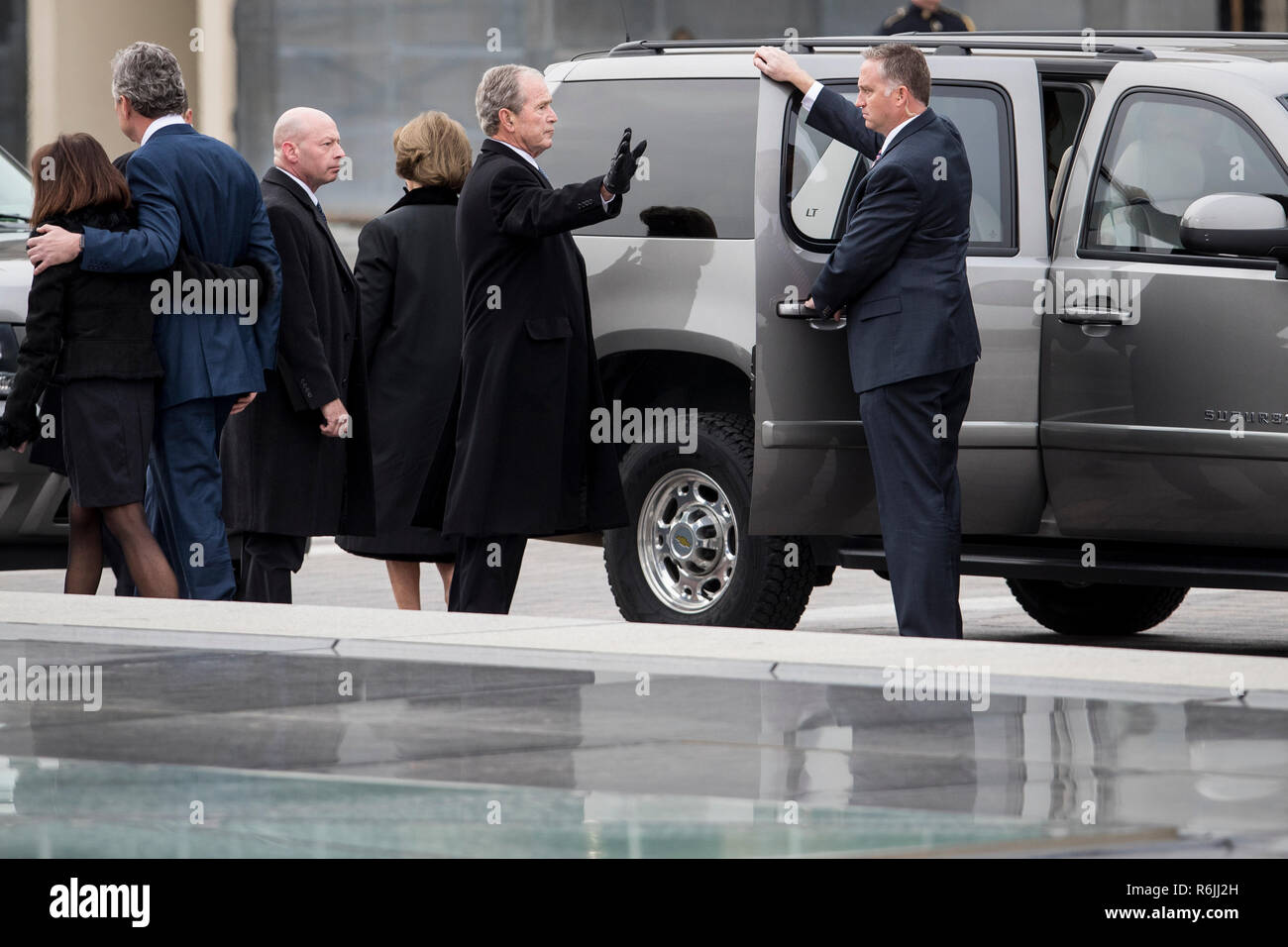 Former President George W. Bush waves to the crowd gathered to view the remains of President George H.W. Bush be transported from the U.S. Capitol to the National Cathedral Wednesday December 5, 2018.  Credit: Sarah Silbiger / Pool via CNP | usage worldwide Stock Photo
