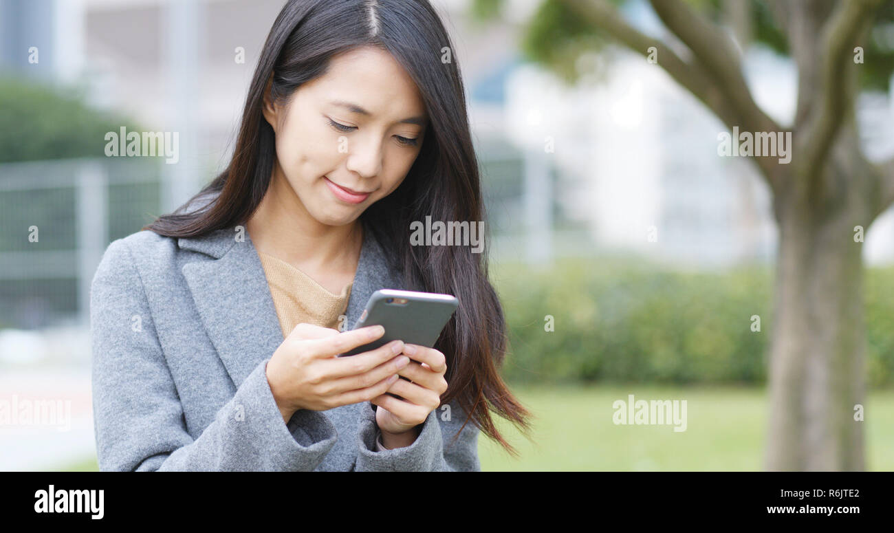 Business woman look at mobile phone in city Stock Photo - Alamy