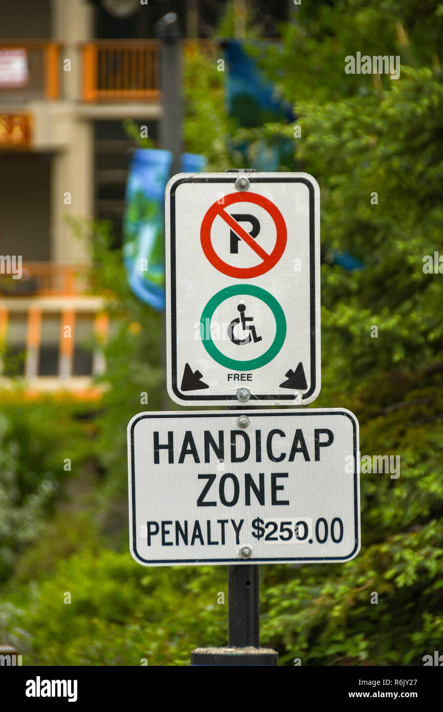CANMORE, ALBERTA, CANADA - MAY 2018: Close up view of a sign in a hotel car park informing visitors of a disabled parking area and penalty fines for t Stock Photo