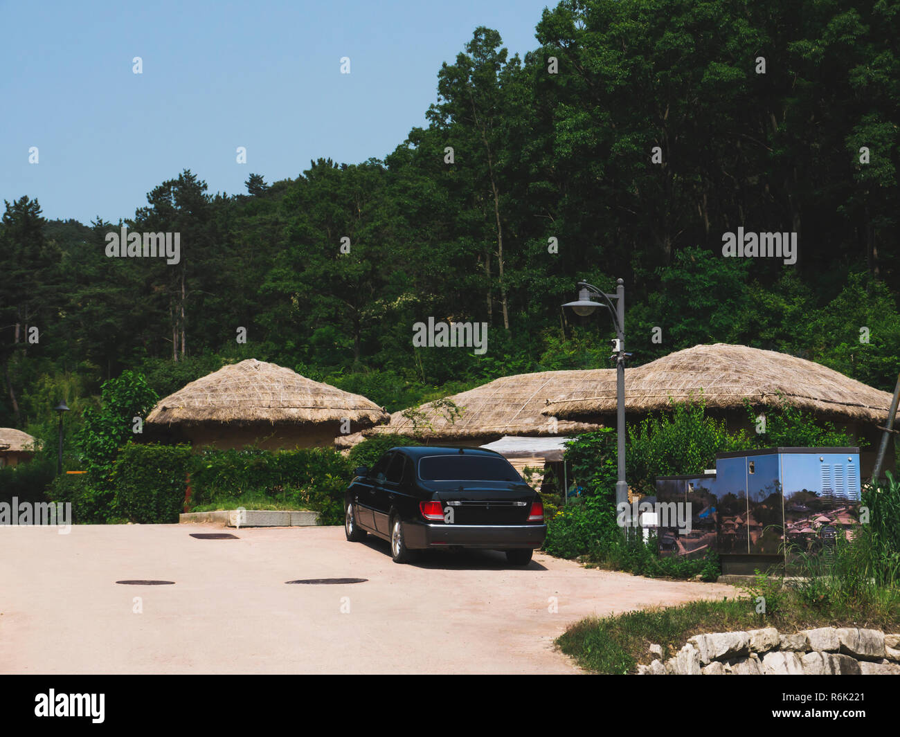 Thatched houses and the modern car in the traditional asian village in ...