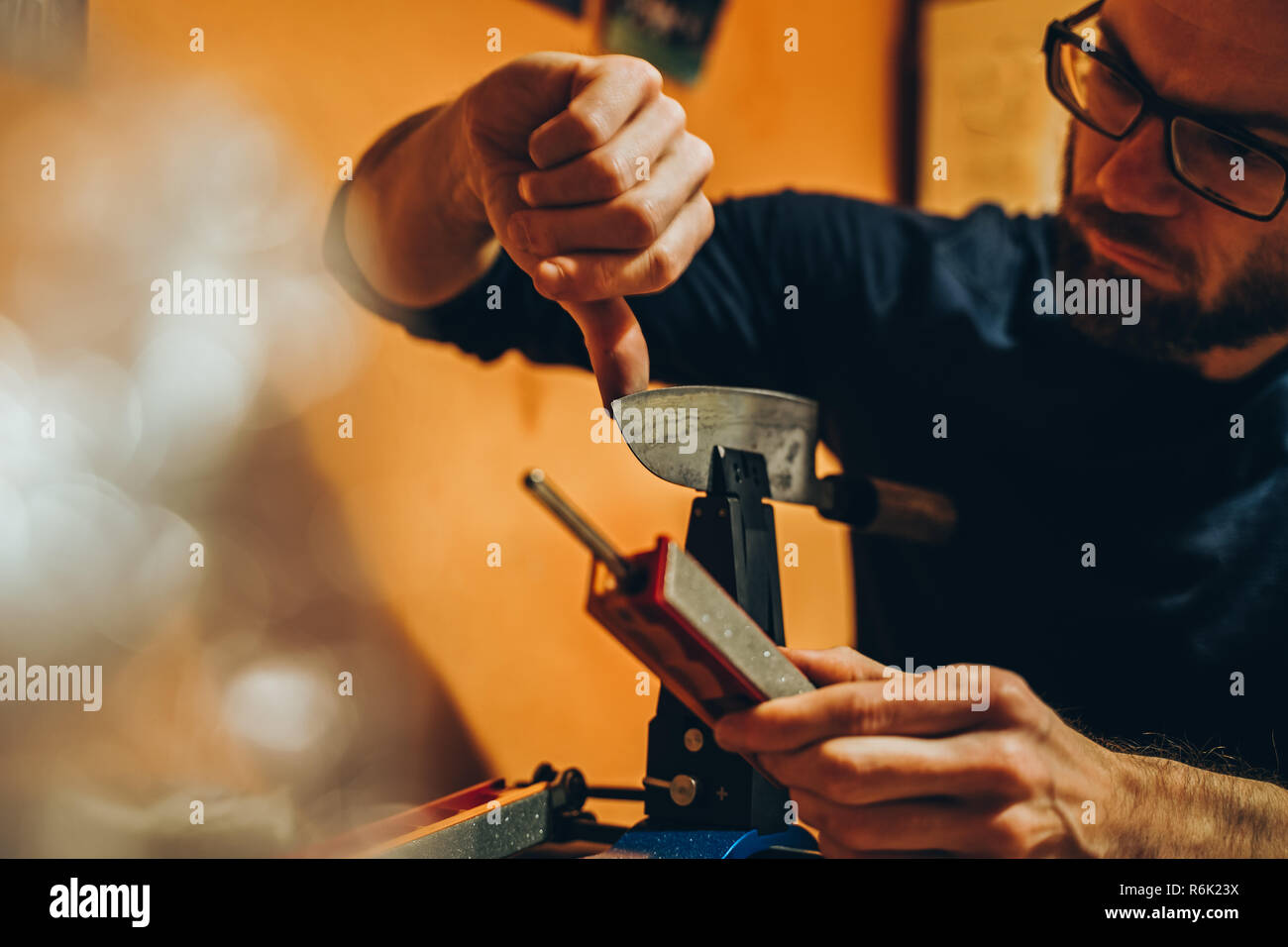 https://c8.alamy.com/comp/R6K23X/caucasian-man-is-checking-the-sharpness-of-a-japanese-kitchen-knife-after-sharpening-it-with-a-modern-whetstone-device-R6K23X.jpg