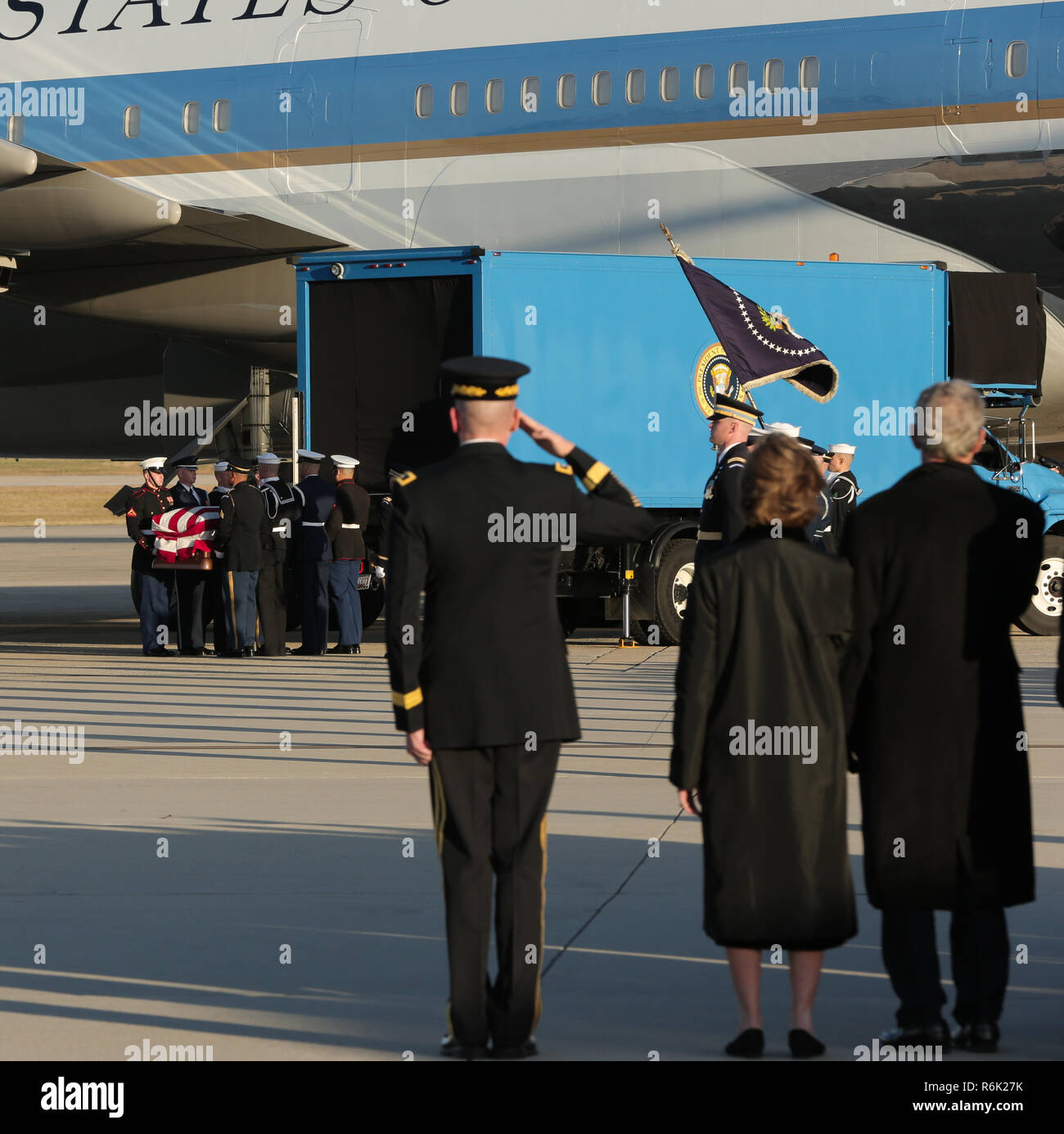 Former President George W. Bush, right, and First Lady Laura Bush, center, stand as Joint Service pallbearers carry the flag-draped casket of his father, former president George H.W. Bush from Air Force One to an awaiting hearse at Joint Base Andrews December 3, 2018 in Andrews, Maryland. Bush, the 41st President, died in his Houston home at age 94. Stock Photo