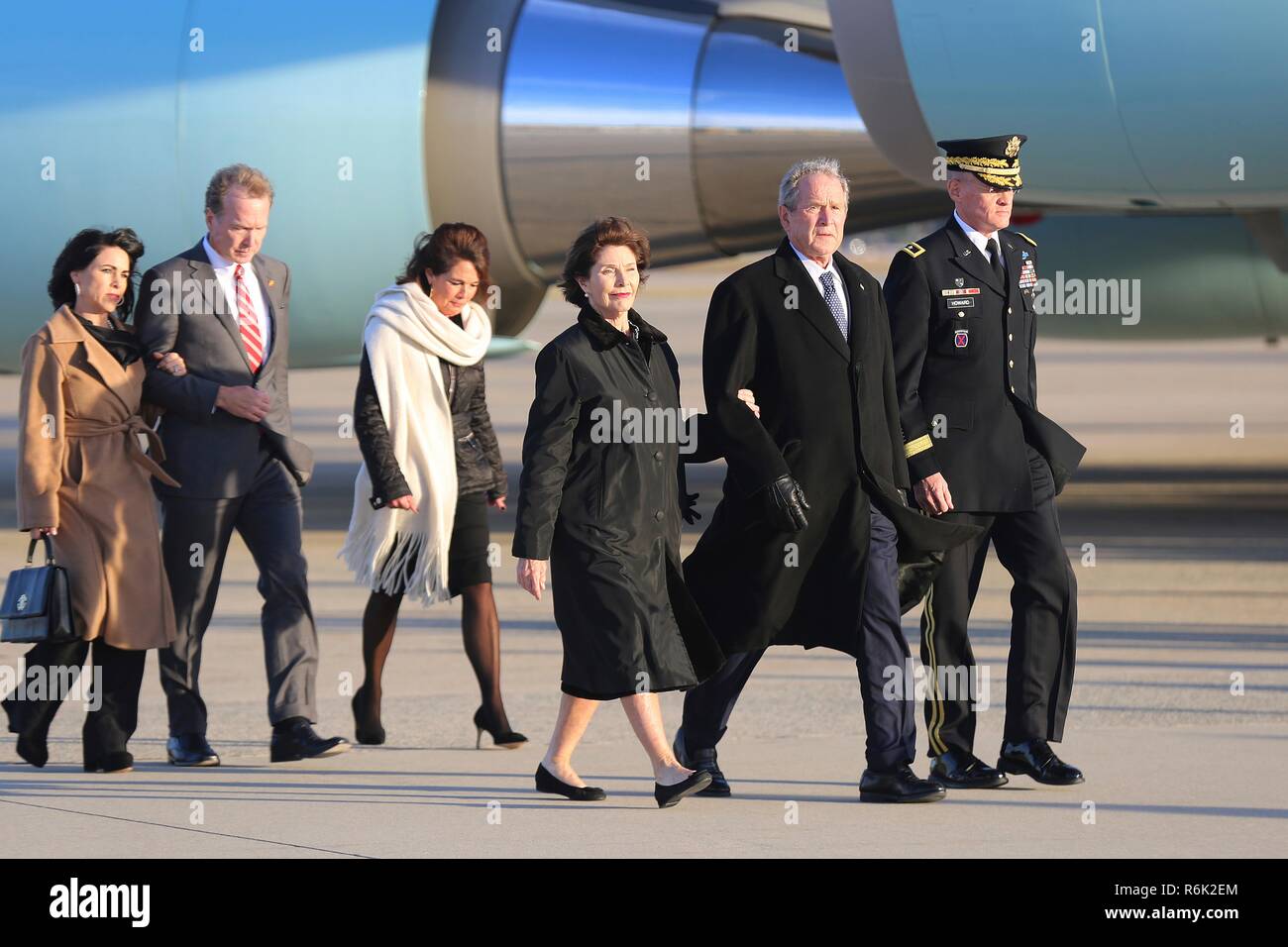 Former President George W. Bush, right, and First Lady Laura Bush, center, arrive from Houston with the the flag-draped casket of his father, former president George H.W. Bush aboard Air Force One December 3, 2018 in Andrews, Maryland. Bush, the 41st President, died in his Houston home at age 94. Stock Photo