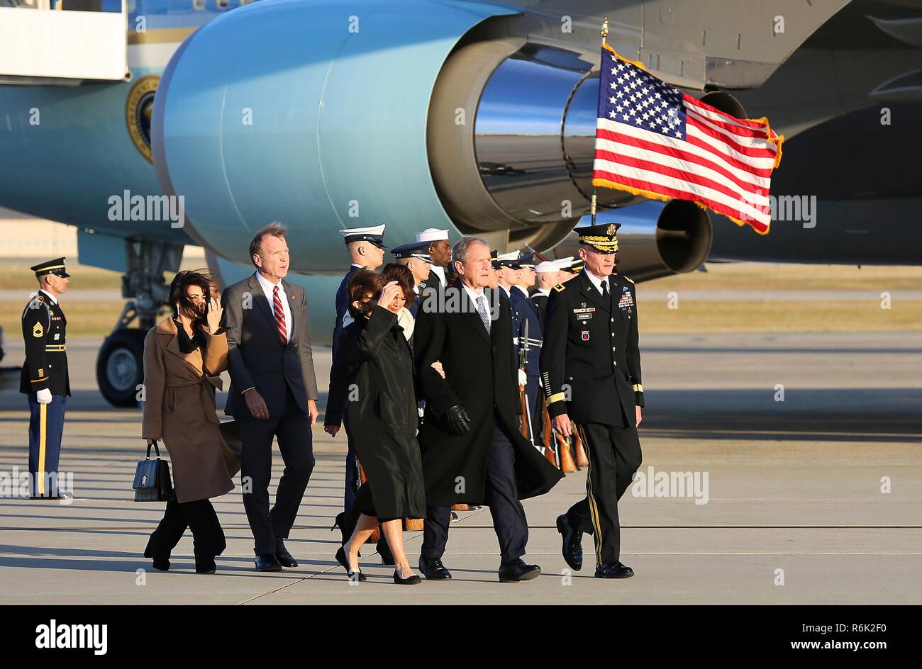 Former President George W. Bush, right, and First Lady Laura Bush, center, and members of the Bush family arrive from Houston with the the flag-draped casket of his father, former president George H.W. Bush aboard Air Force One December 3, 2018 in Andrews, Maryland. Bush, the 41st President, died in his Houston home at age 94. Stock Photo