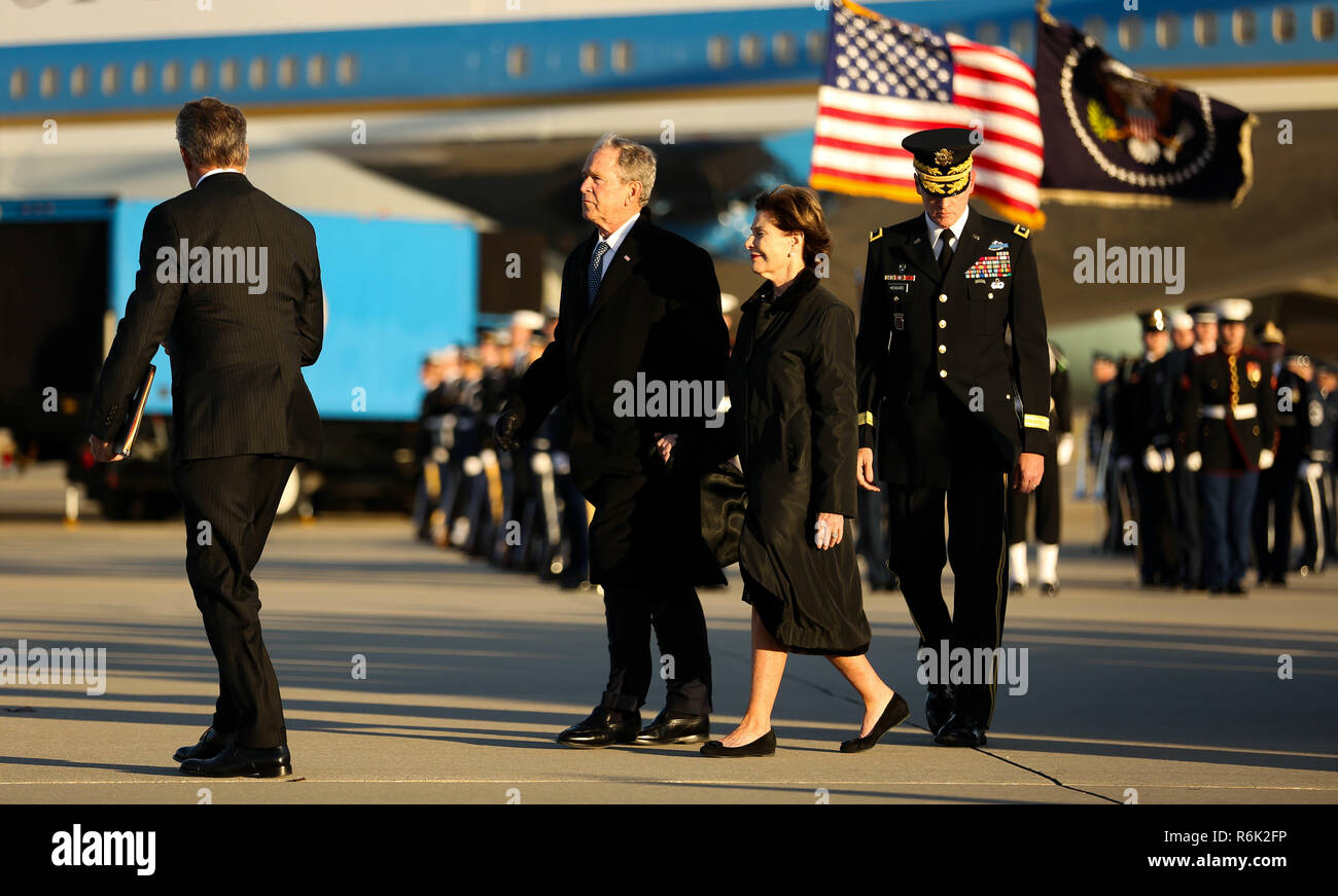 Former President George W. Bush, left, and First Lady Laura Bush, center, arrive from Houston with the the flag-draped casket of his father, former president George H.W. Bush aboard Air Force One December 3, 2018 in Andrews, Maryland. Bush, the 41st President, died in his Houston home at age 94. Stock Photo