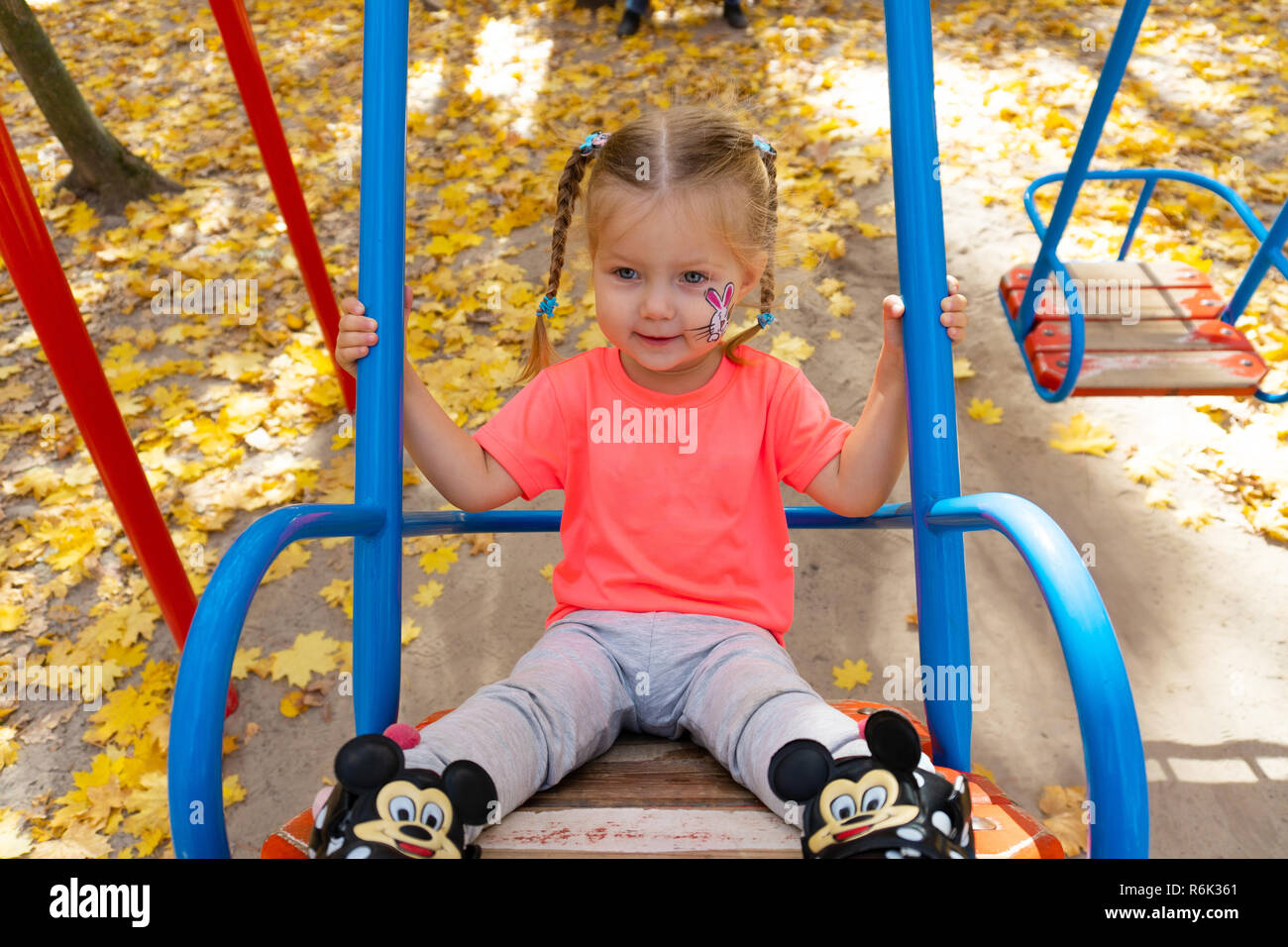 Girl swinging on swing in the park Stock Photo - Alamy