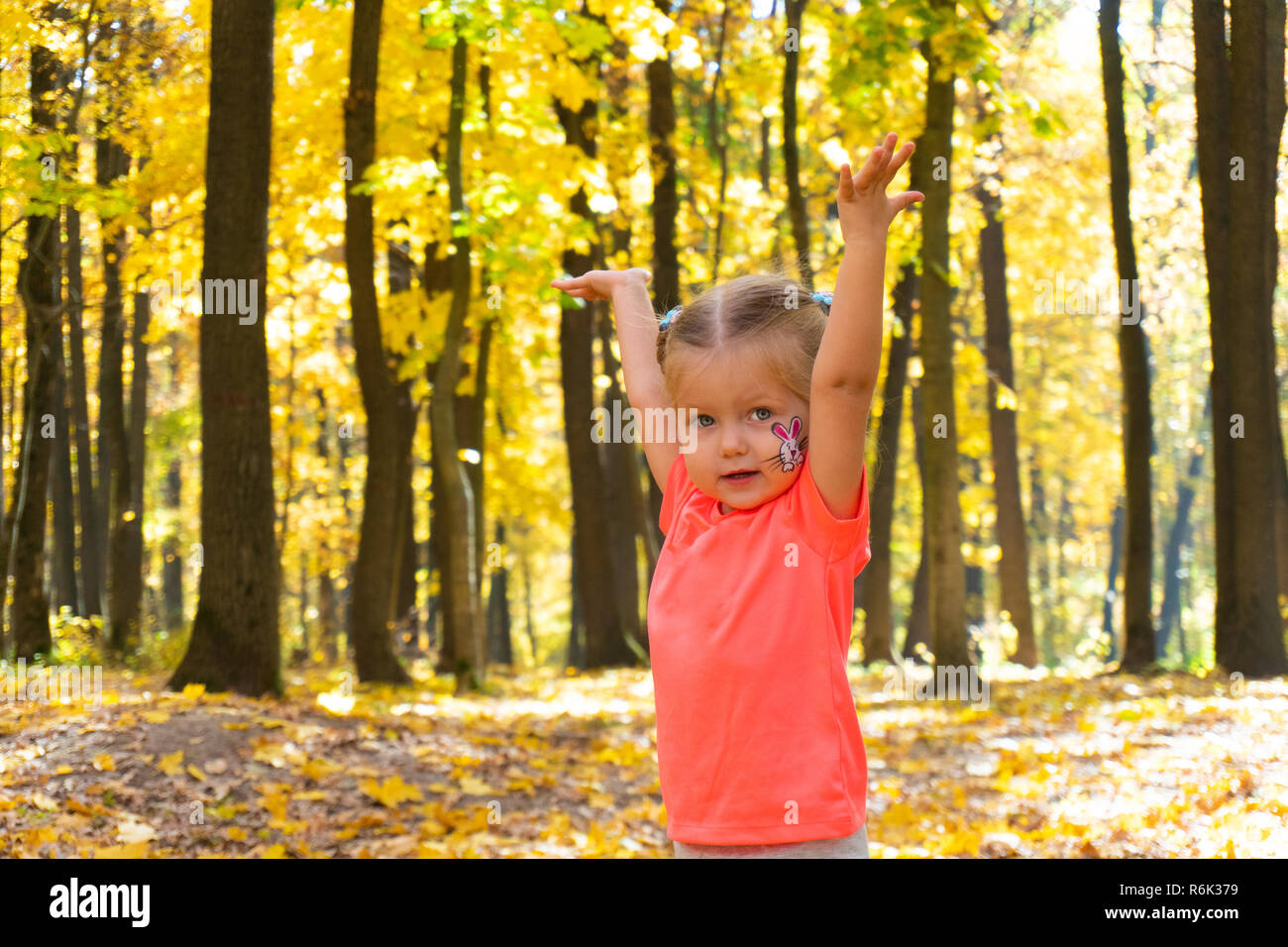 Happy little girl playing in autumn park Stock Photo - Alamy