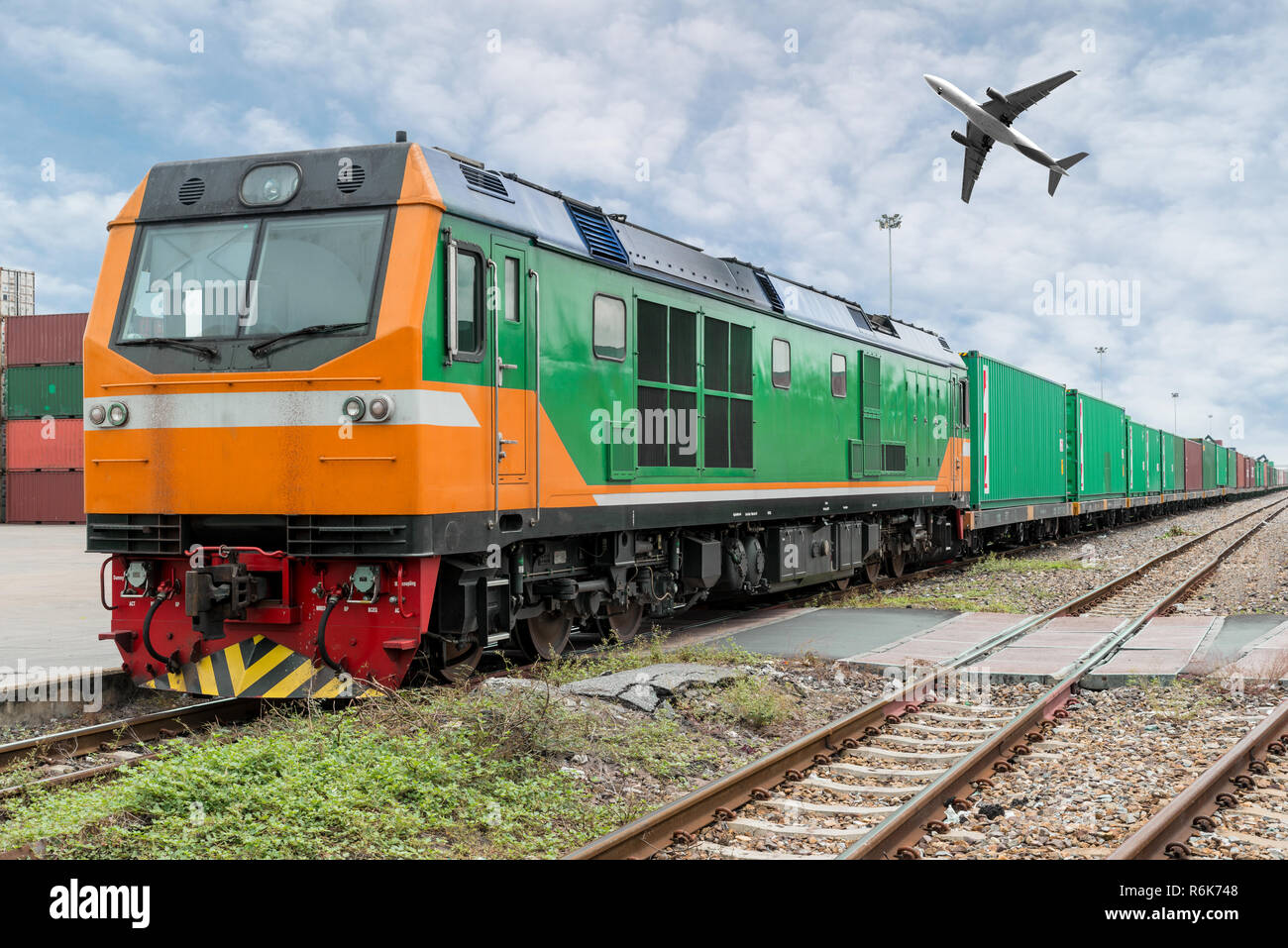 Cargo train platform with freight train container at depot with cargo airplane in port use for export logistics background. Stock Photo