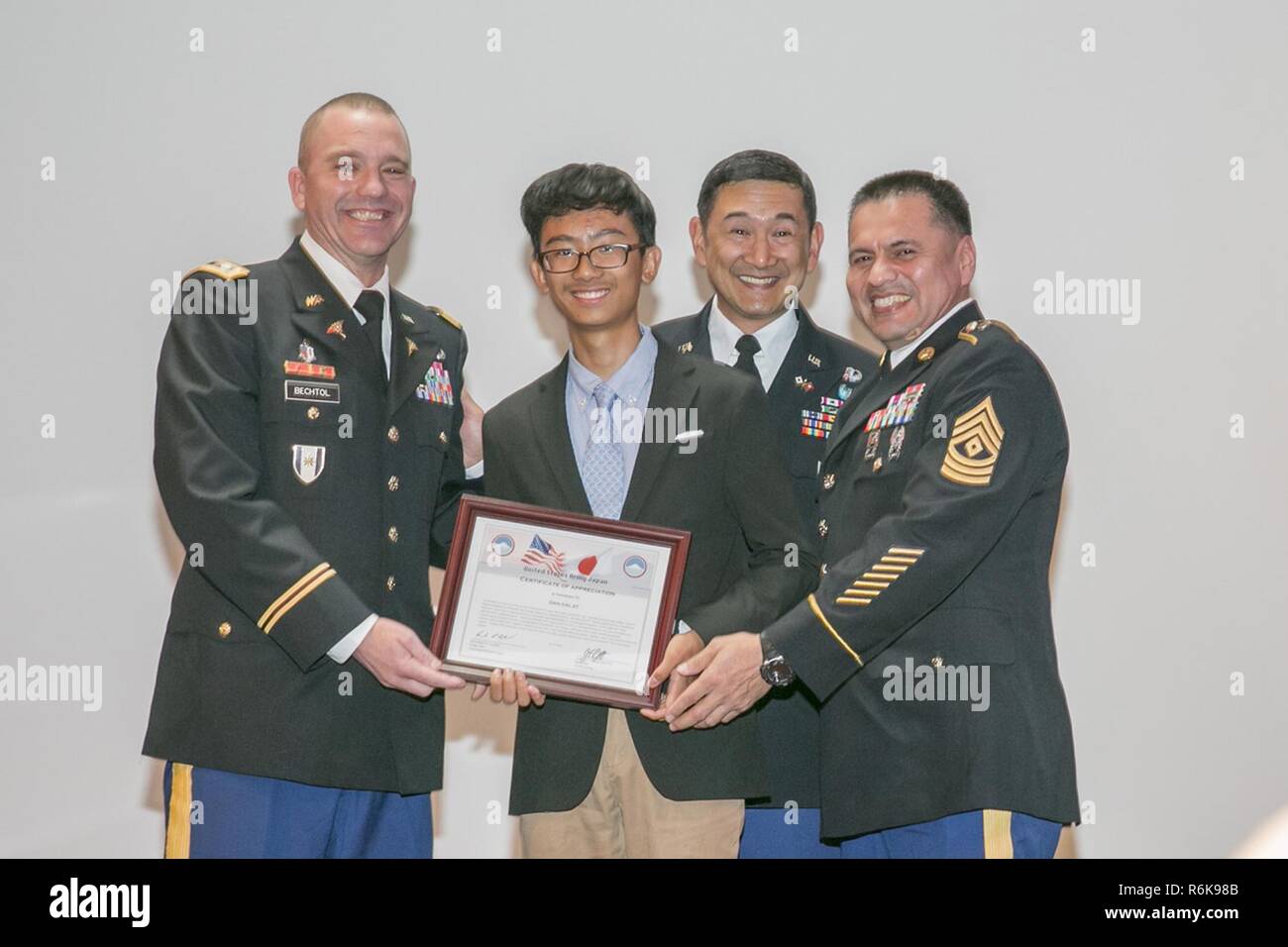 Dan Dalat, center, senior at Zama American High School, receives an award for introducing his father at the Asian American Pacific Islander Heritage Month Observance May 18, 2017 at Camp Zama Community Club. Stock Photo