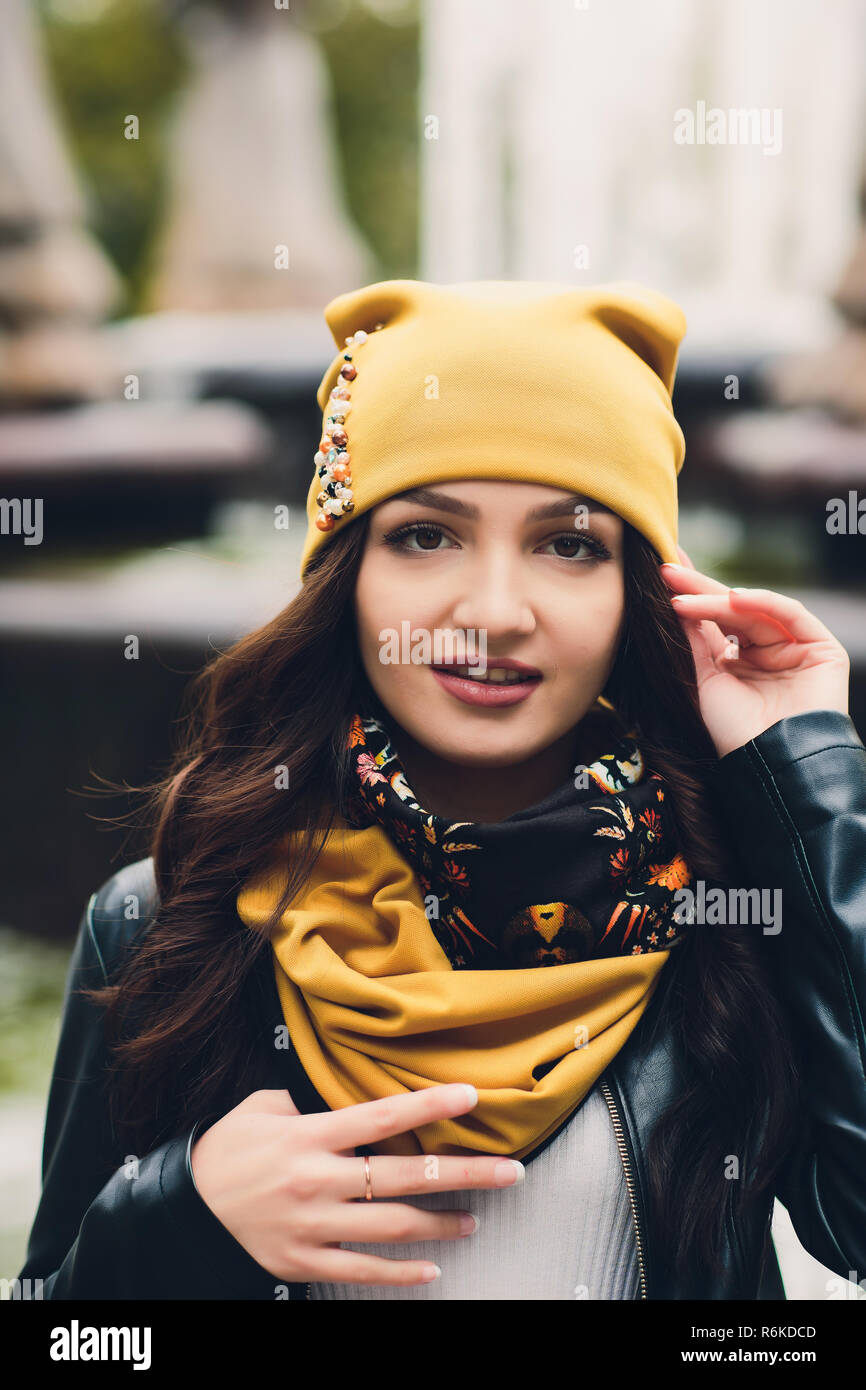 Portrait of funny young girl in the autumn weather in warm clothes and