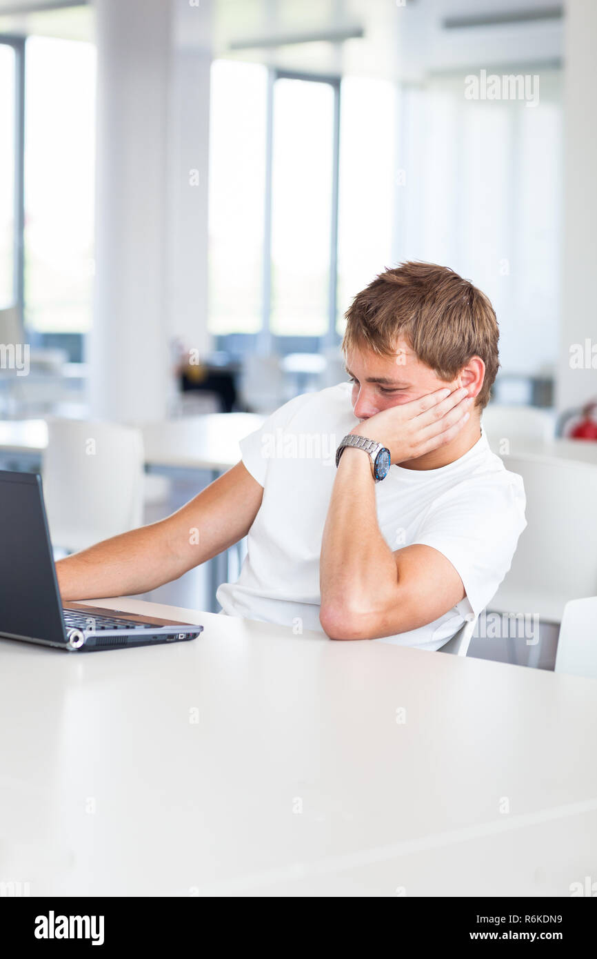 Handsome College Student With Laptop Computer In University