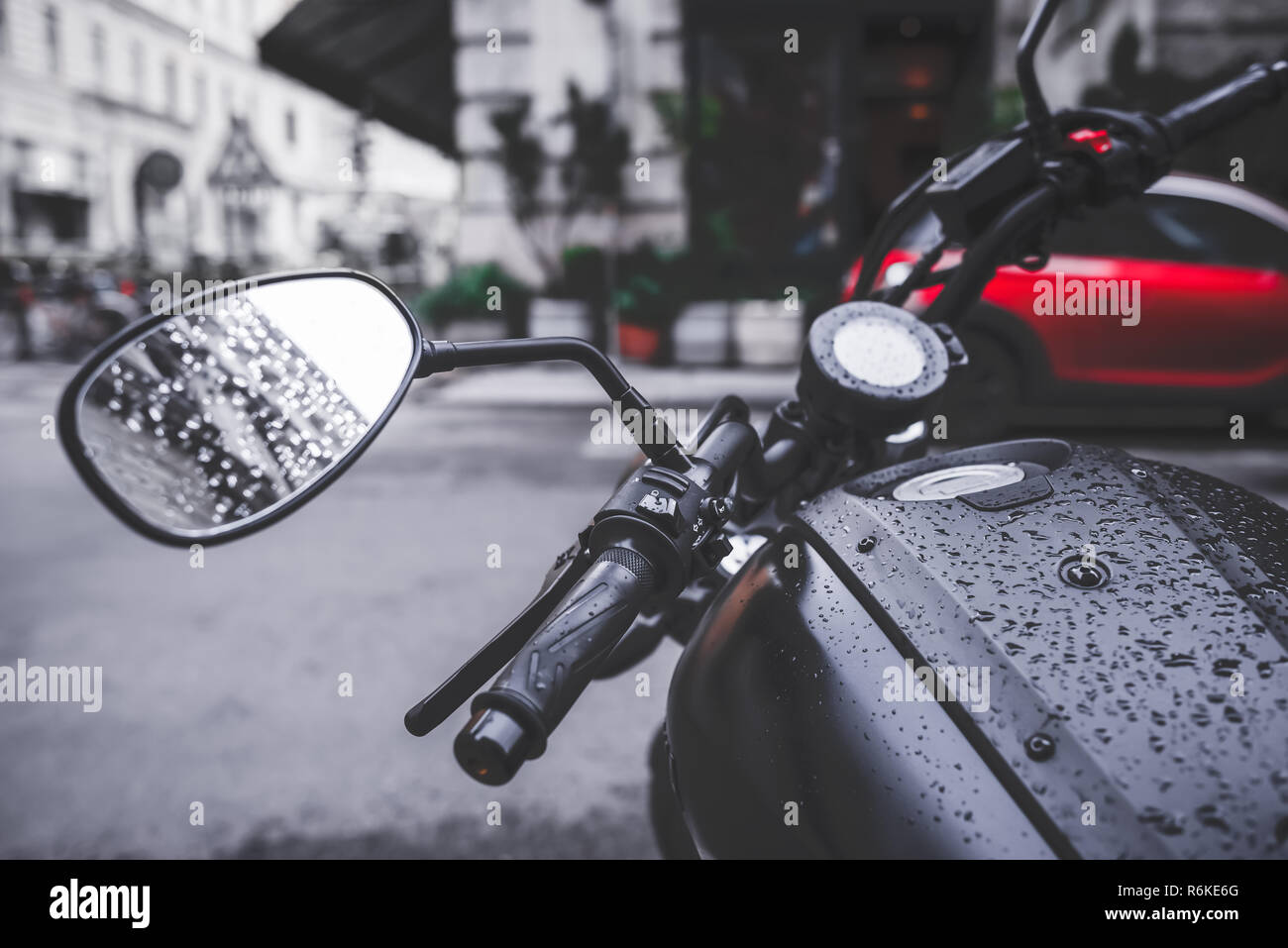 Black motorcycle at raindrops on the city street. Urban black white red photo Stock Photo