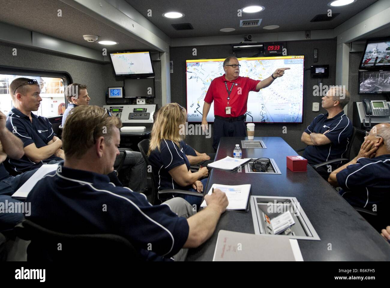 William Burket, director of emergency operations at the Virginia Port Authority in Norfolk, Virginia, explains the capabilities of the Port Authority Command 1 (PAC-1) to students from Queensland University of Technology in Brisbane, Queensland, Australia during their tour of Coast Guard Sector Hampton Roads in Portsmouth, Virginia, May 25, 2017. Burket described how the Coast Guard utilizes PAC-1 during interagency response operations. Stock Photo