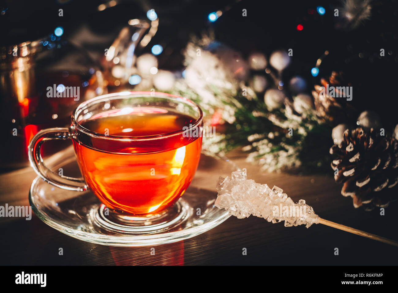 Hot glass cup of black tea on table decorated with christmas tree toys Stock Photo