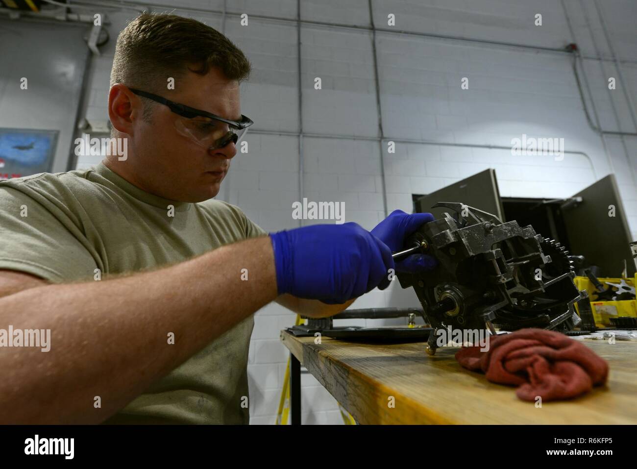 U.S. Air Force Airman 1st Class Michael Tilton, 20th Equipment Maintenance Squadron weapons technician, uses a hammer and punch to secure roll pins on a M61A1 Vulcan 20 mm rotary cannon exit unit at Shaw Air Force Base, S.C., May 22, 2017. The roll pins hold sprockets on the unit’s gear shaft, allowing the unit to pull munitions from the drum and towards the gun. Stock Photo