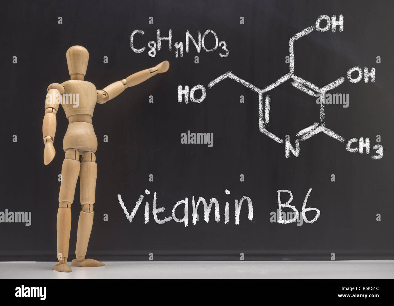 Doll articulated teaches in a blackboard the chemical composition of the vitamin B6, conceptual image Stock Photo